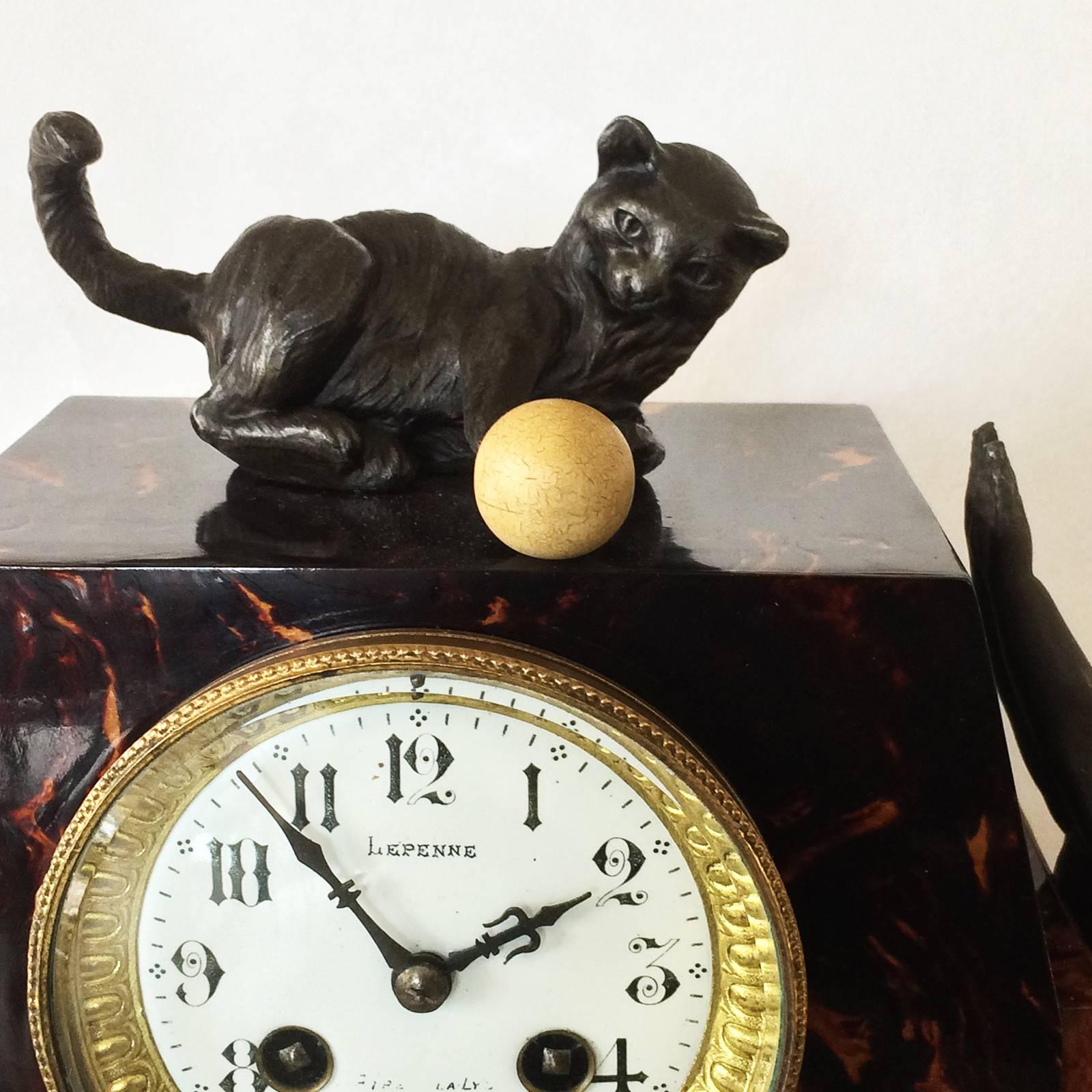 French clock faux tortoise shell, celluloid laminated on timber frame, with children playing with cat and ball of very early celluloid. An amazing historical piece, extremely rare and finely decorated. The clock is suspended above, exposing the