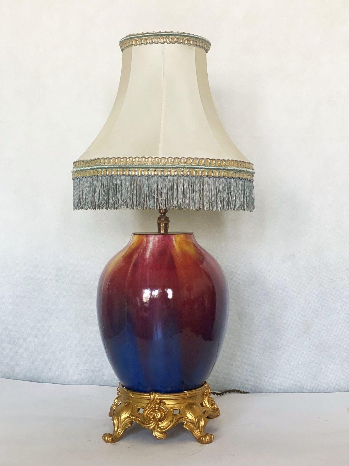 Une grande lampe de table rare en céramique fabriquée à la main, France 1930-1939. Peint à la main et émaillé de couleurs vibrantes, abat-jour original en soie de couleur ivoire avec des franges bleu clair. Une douille pour une ampoule de grande