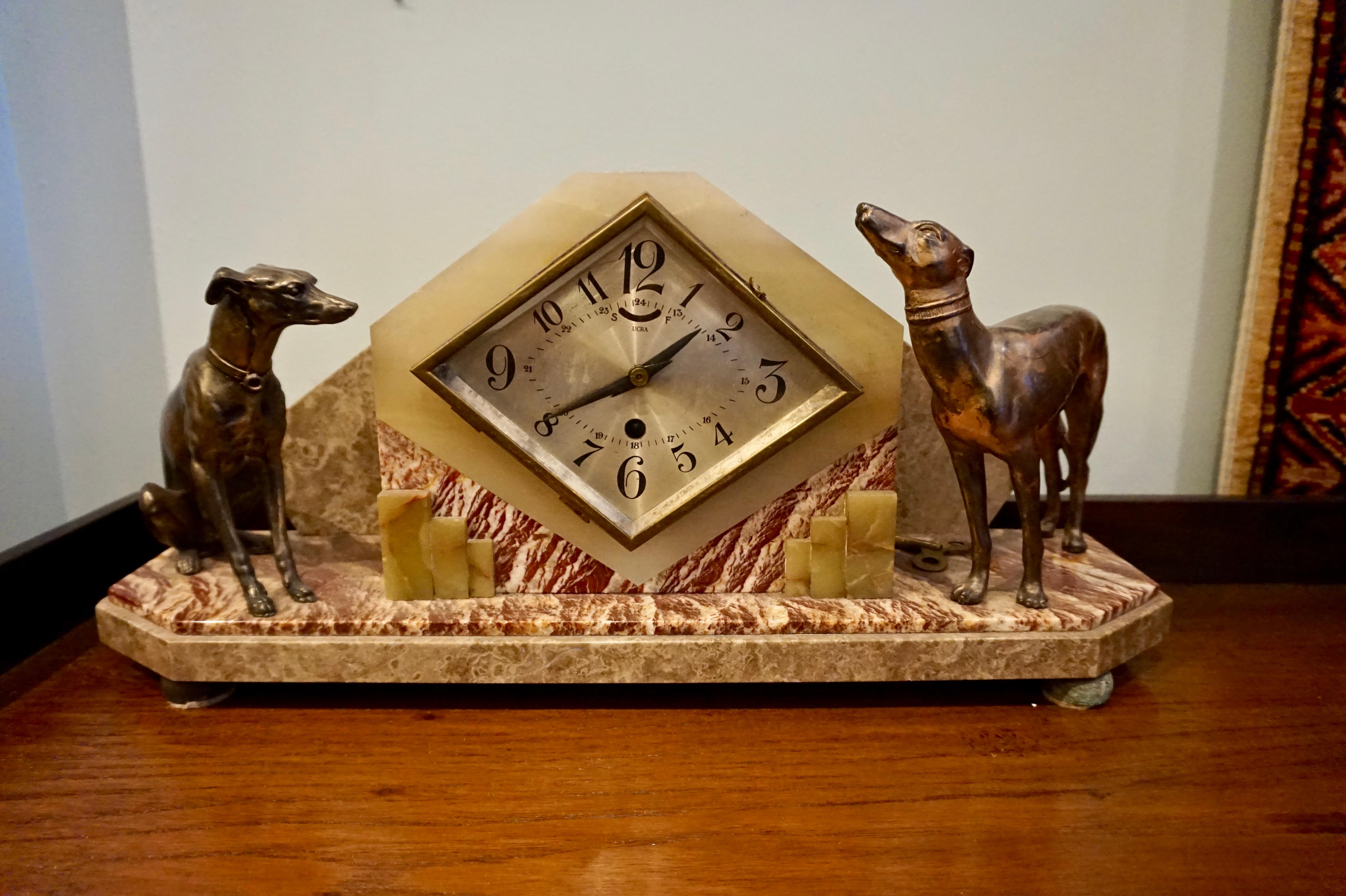 Circa 1935

Rare Art Deco mantel clock exquisitely made with marble and onyx with surreal dog figurines in contrasting poses. Original patination. Statement piece.