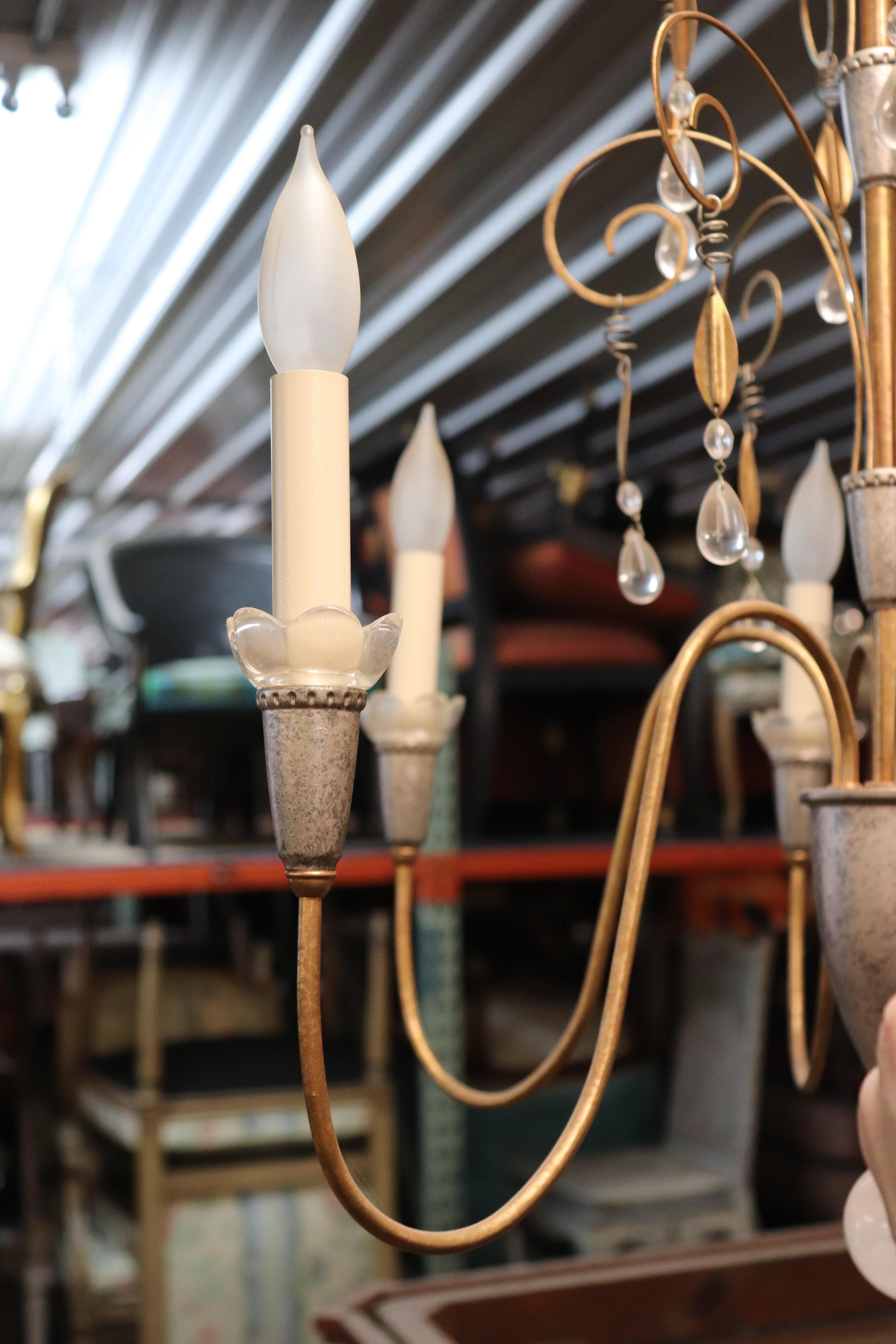 Si tratta di un lampadario Hollywood Regency o Art Deco superbo ed estremamente sofisticato. Il lampadario è progettato in modo sobrio ed elegante, senza troppi ornamenti o decorazioni. Il lampadario è in buone condizioni e credo che i cristalli