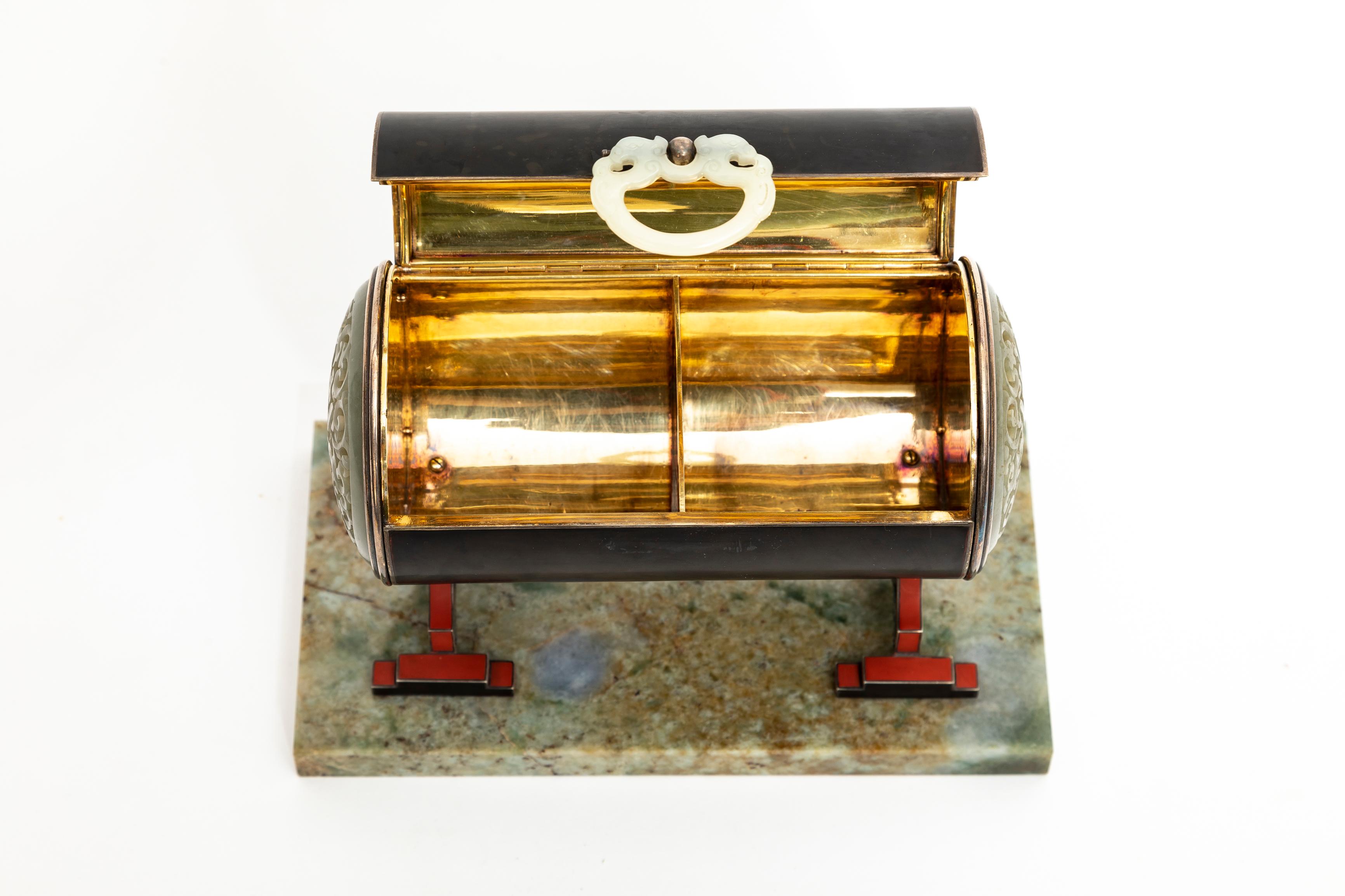 Caja doble de plata, esmalte y jade chino del periodo Art Déco francés, atribuida a Cartier. La caja tiene forma de tonel y está acabada en esmalte negro. Descansa sobre un par de soportes de plata de estilo chino, esmaltados en rojo y con elementos