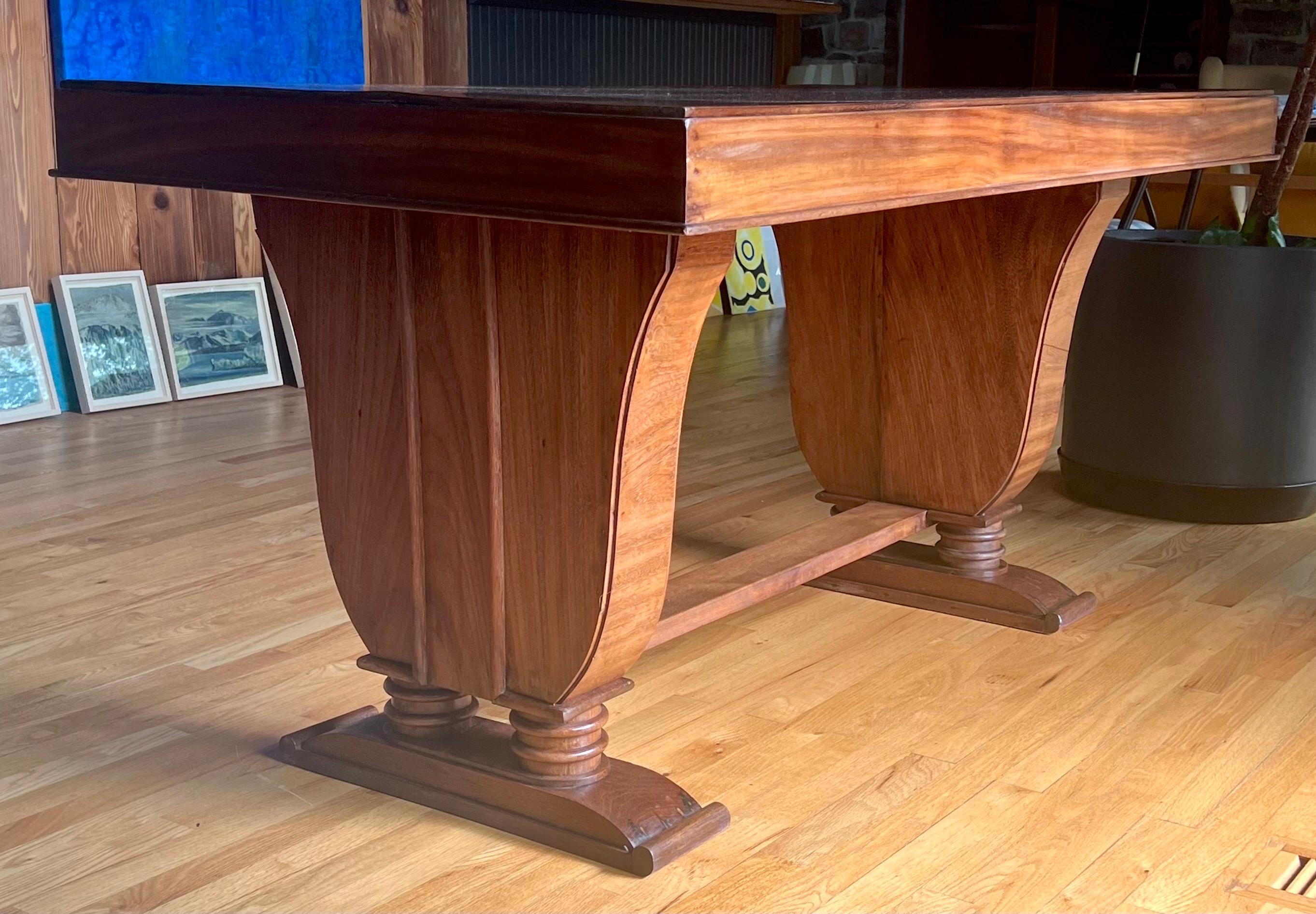 Elegant and Timeless French Art Deco Writing Table / Desk in Teak Wood circa 1925. This rare and original piece has an exquisite sense of line, form and volume that creates a dramatic, yet subtle presence. The design and construction of this work is