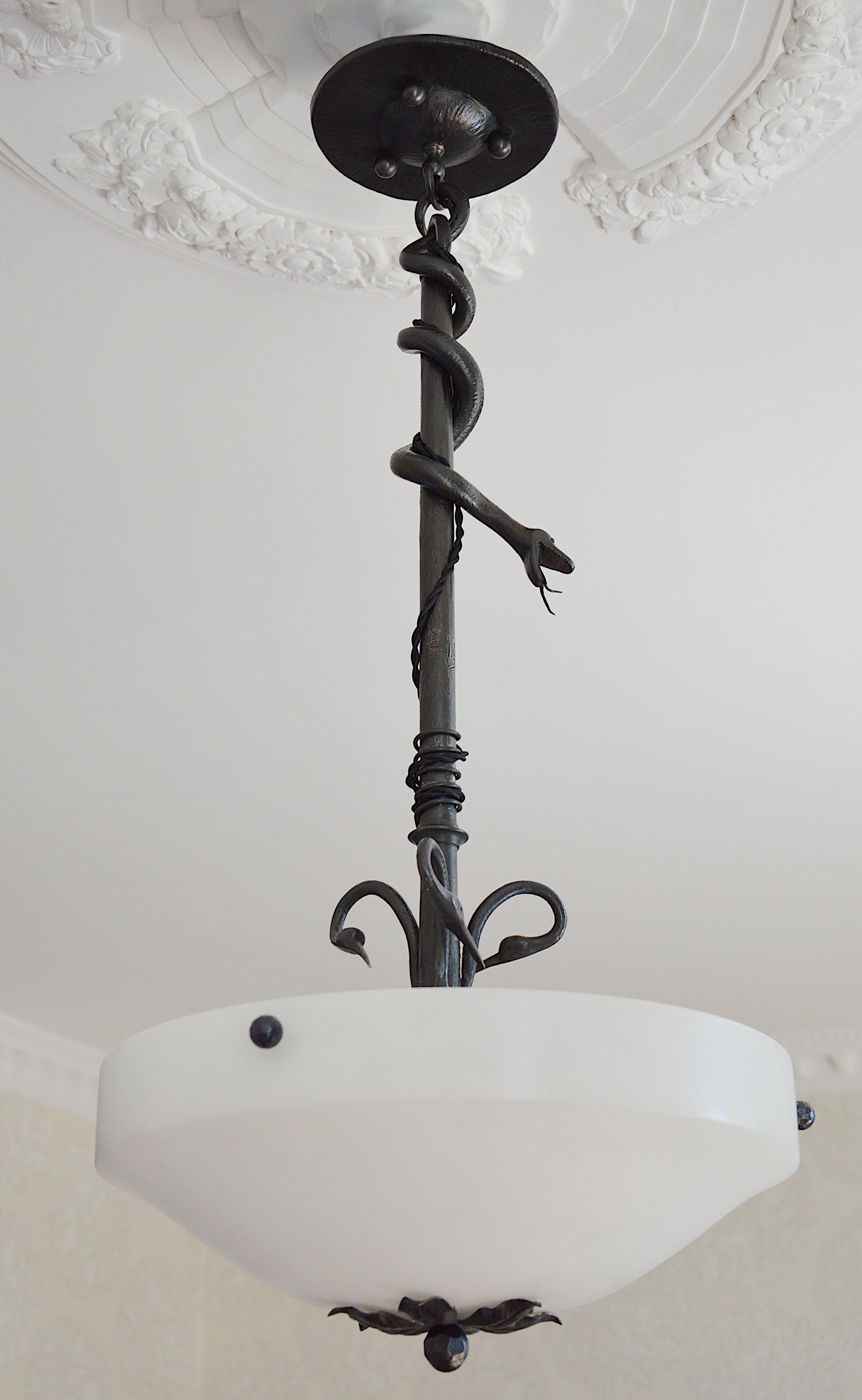 French Art Deco Chandelier, 1928 – Alabaster Shade with Wrought Iron Frame. This rare and exceptional French Art Deco chandelier, made in 1928, features a magnificent alabaster shade suspended from an intricate wrought iron frame. Its unique design