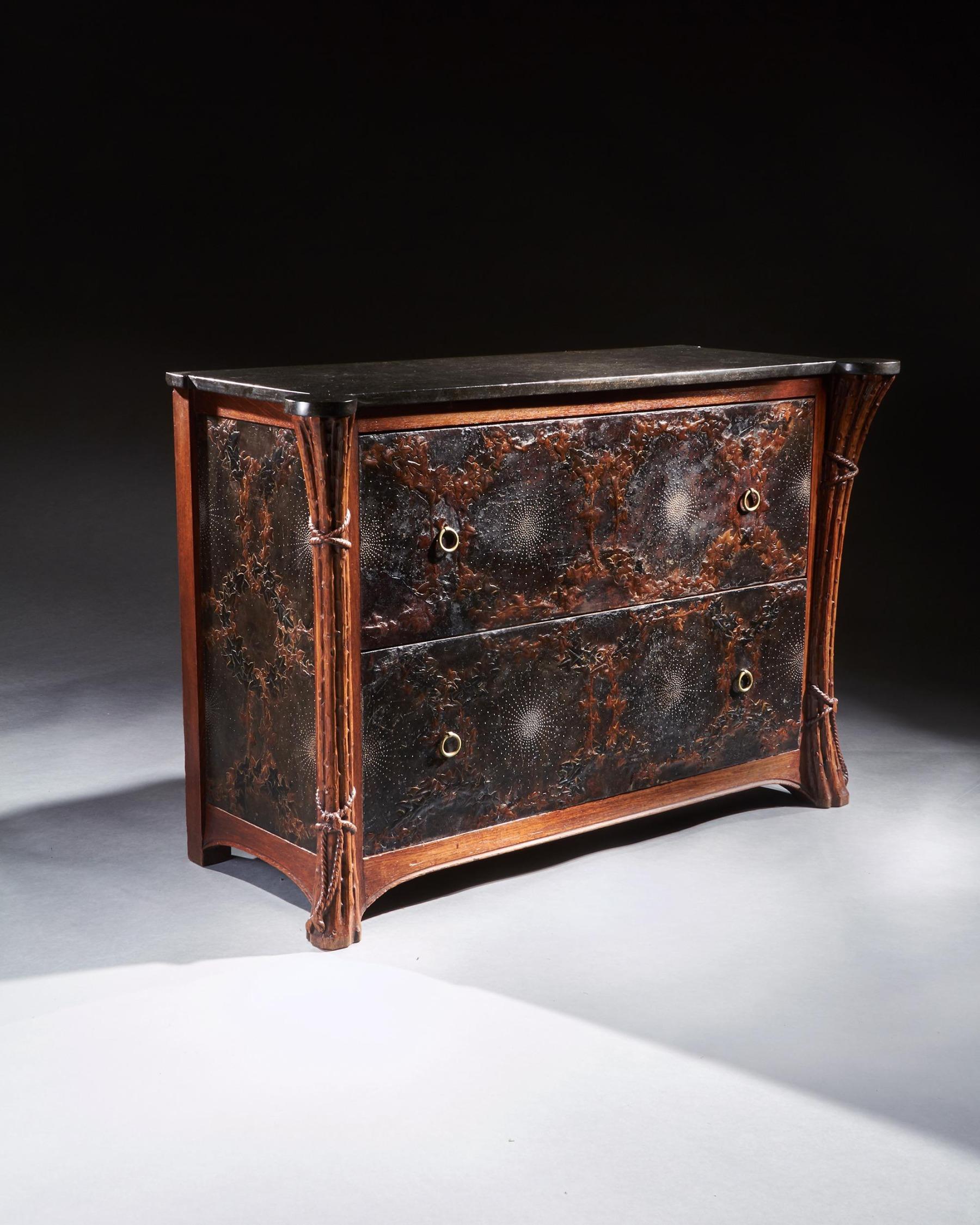 A wonderful and rare French Art Nouveau leather lined and bronze studded marble top commode.



French Circa 1900



The black fossiliferous marble top with out-curved front corners above two long drawers embossed with leather ivy wreaths