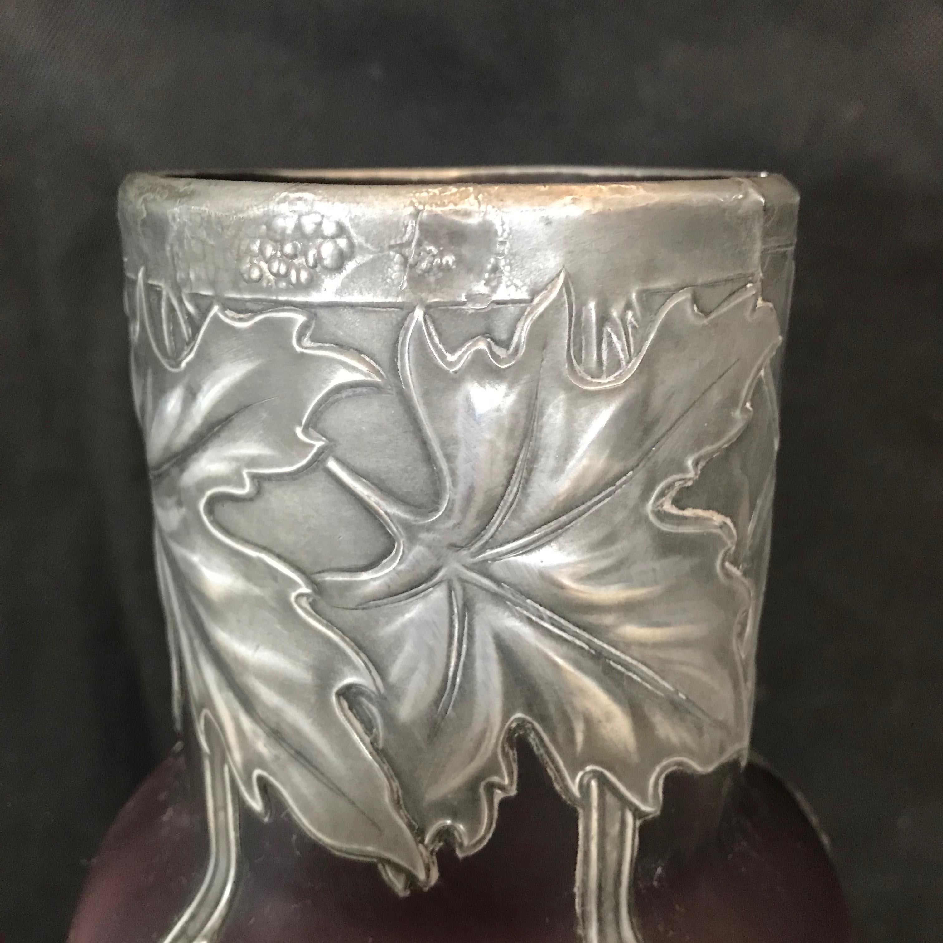 A French pewter mounted opalescent violet glass vase. Art Nouveau style frosted pale violet opalescent art glass set with floral and berry metal overlay and central monogram. Opening at top 3 5/8