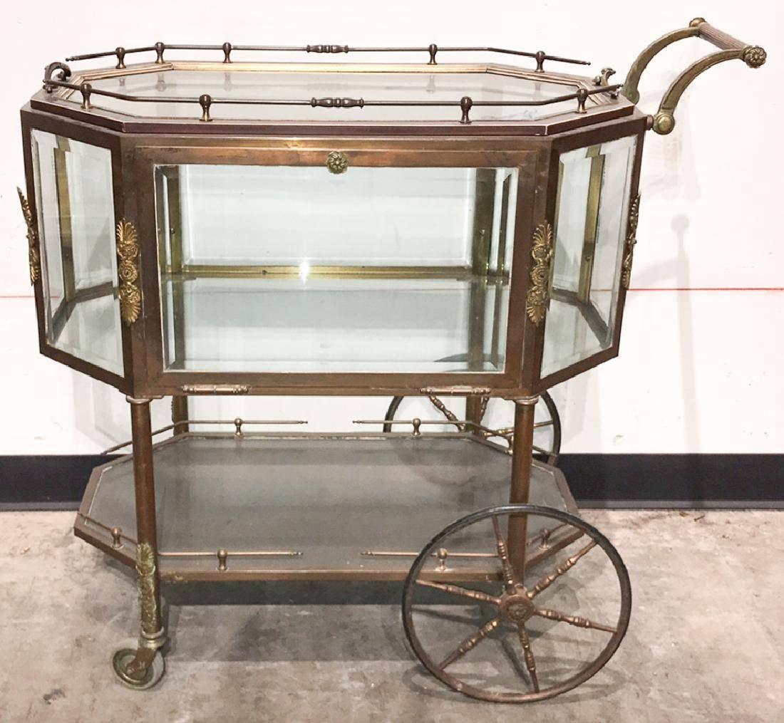 Highly desirable and rare antique French octagonal brass tea or bar cart with inset beveled glass and ormolu appliques The fold down door above a lower tier with gallery border on spoked wheels, circa 1920.

The tray top removes for serving.