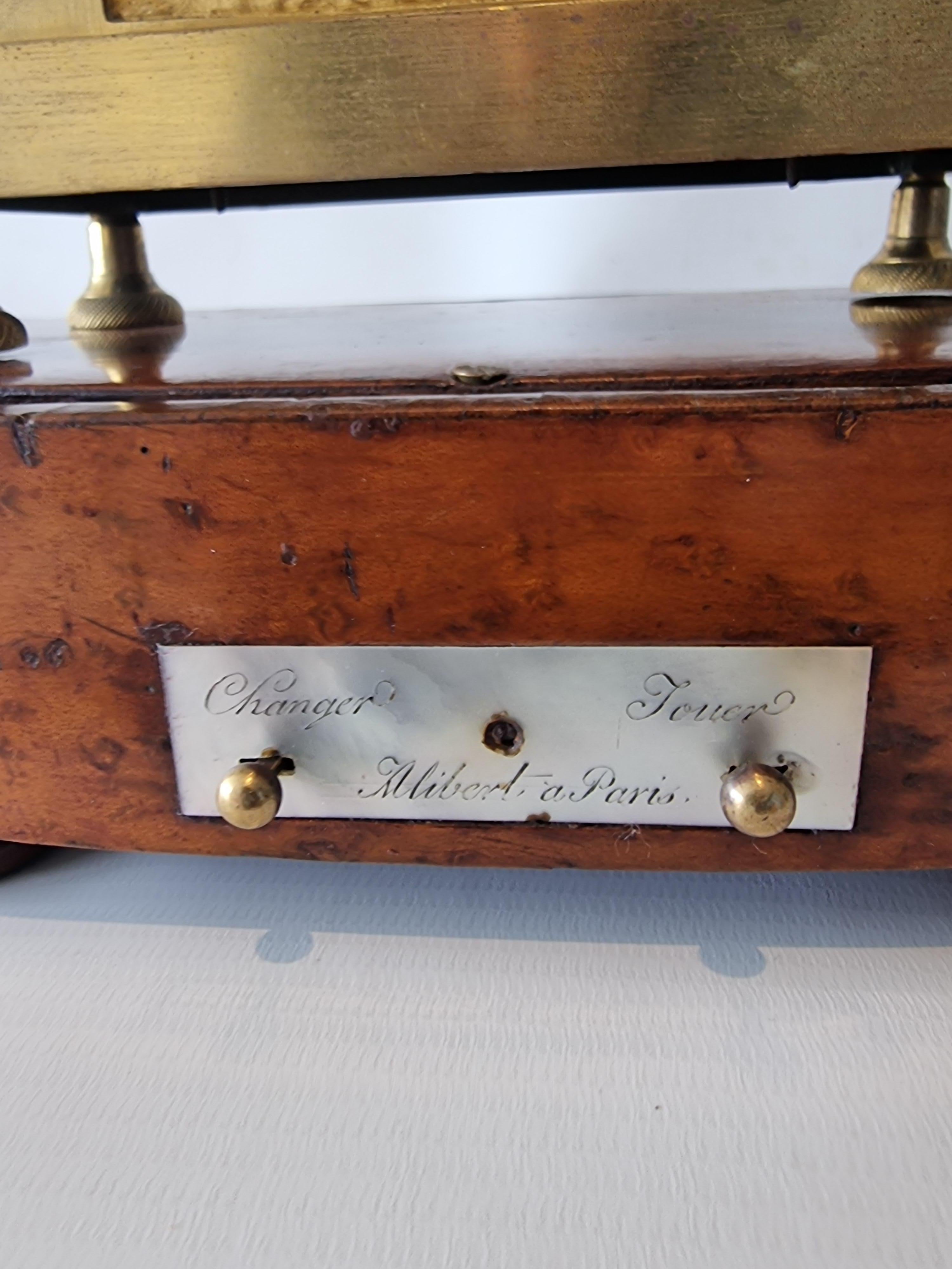 Rarissima pendola da camino francese Impero in ormolu e bronzo patinato firmata Alibert con base musicale a due melodie anch'essa firmata Alibert. Questo modello si basa su un disegno di Jean Andre Reiche. Questo modello poggia su una superba base