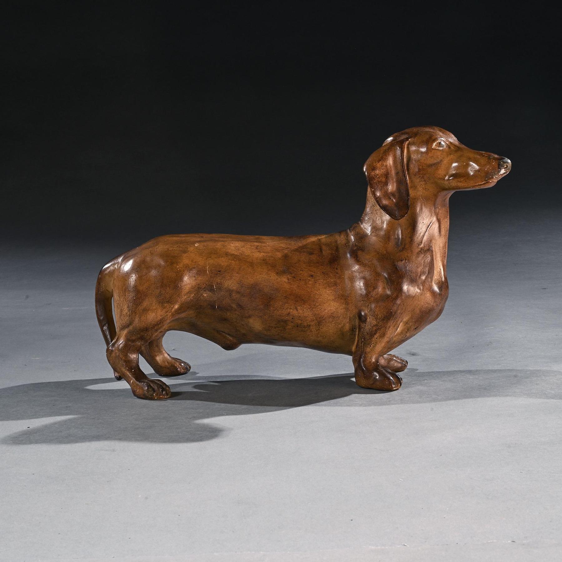 A Rare French Life-like Glazed Terracotta Sculpture of a Dachshund Dog

French Circa 1920

This charming piece depicts a Dachshund, commonly known as the sausage dog. The breed was established primarily to flush out badgers and other burrow-dwelling