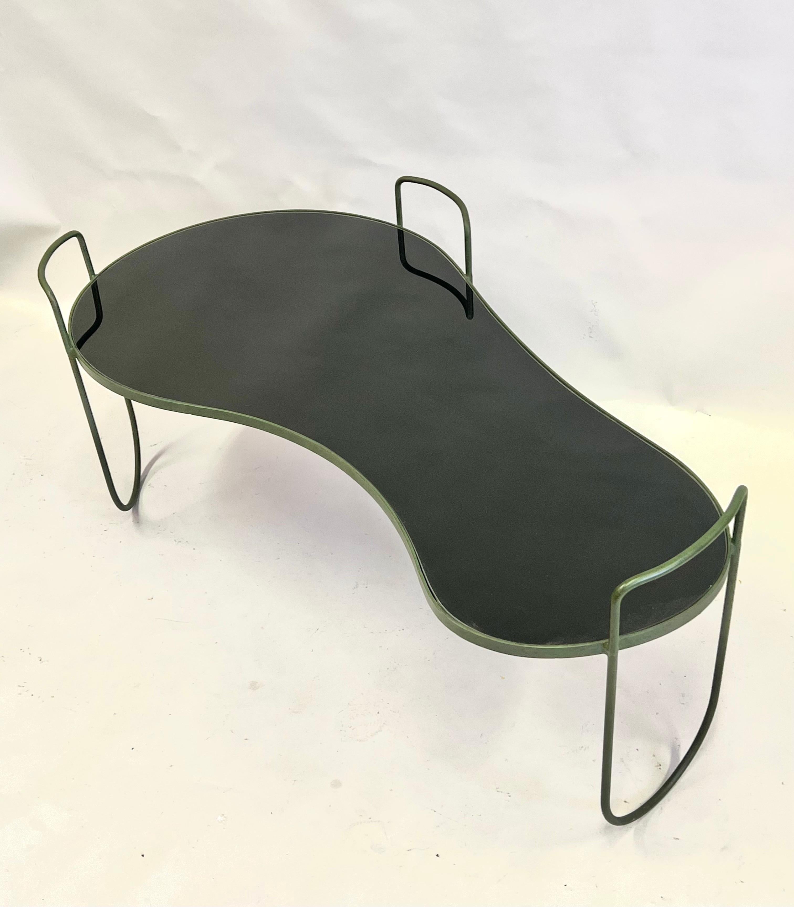 A rare and important French Mid-Century Modern cocktail table. This exceptional piece features an organic form top suspended from 3 curved, organic form wrought iron supports This unique support system renders the experience of the table floating in
