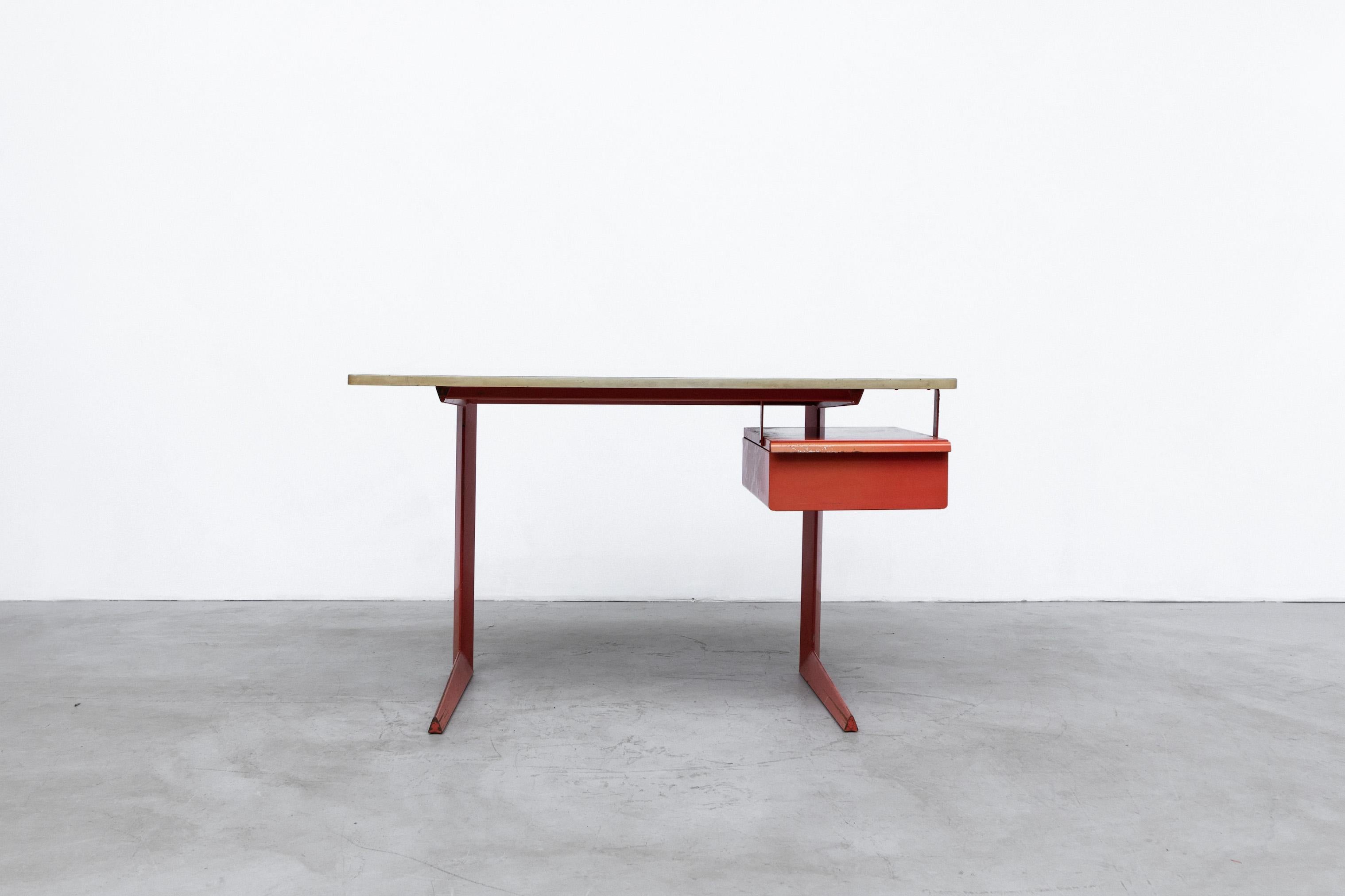 Rare Friso Kramer teachers desk with faux linen printed Formica top and red enameled metal frame with floating drawer. In original condition with visible wear and scratching with some fading to the enamel. Drawer interior dims 14.75 x 18.75 x