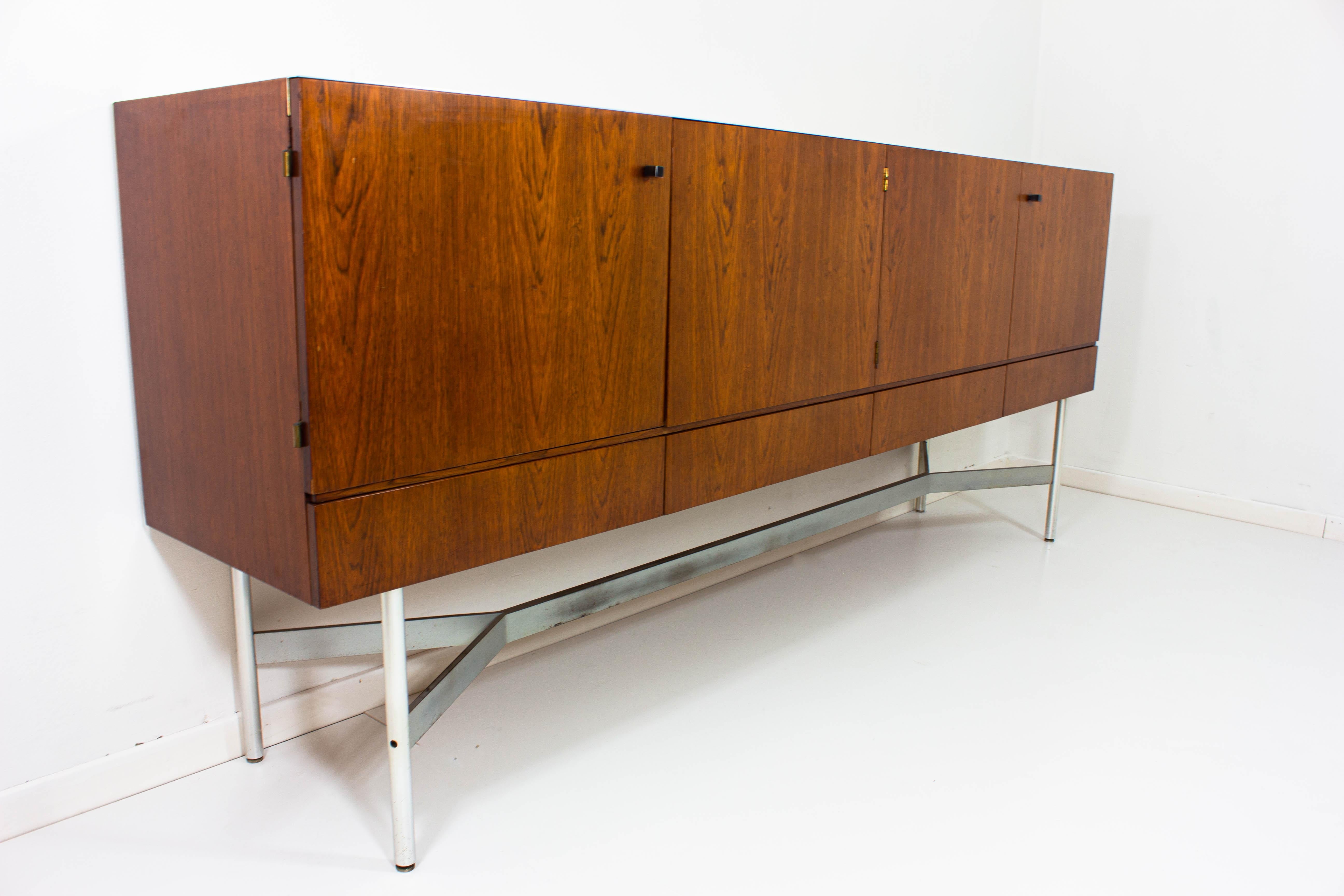 Very well crafted sideboard (and accompanying bar cabinet) with beautiful proportions. The elegant brushed metal base and legs contrast beautifully with the wooden body of the pieces. The veneered doors show a nice deep wooden pattern while the base