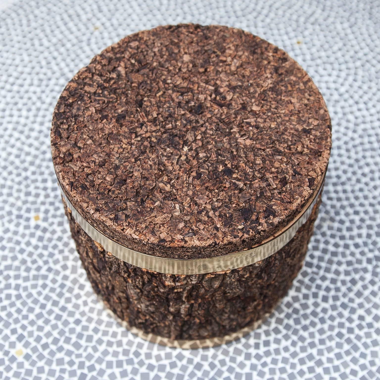 Wonderful and rare ice bucket or desk box designed by Gabriella Crespi in the 1970s.
Very textural cork covers contrast with the polished brass ring and a glass inlay. 
An Ultimate luxury item.
Measures: 25 H x 26 D cm.

 