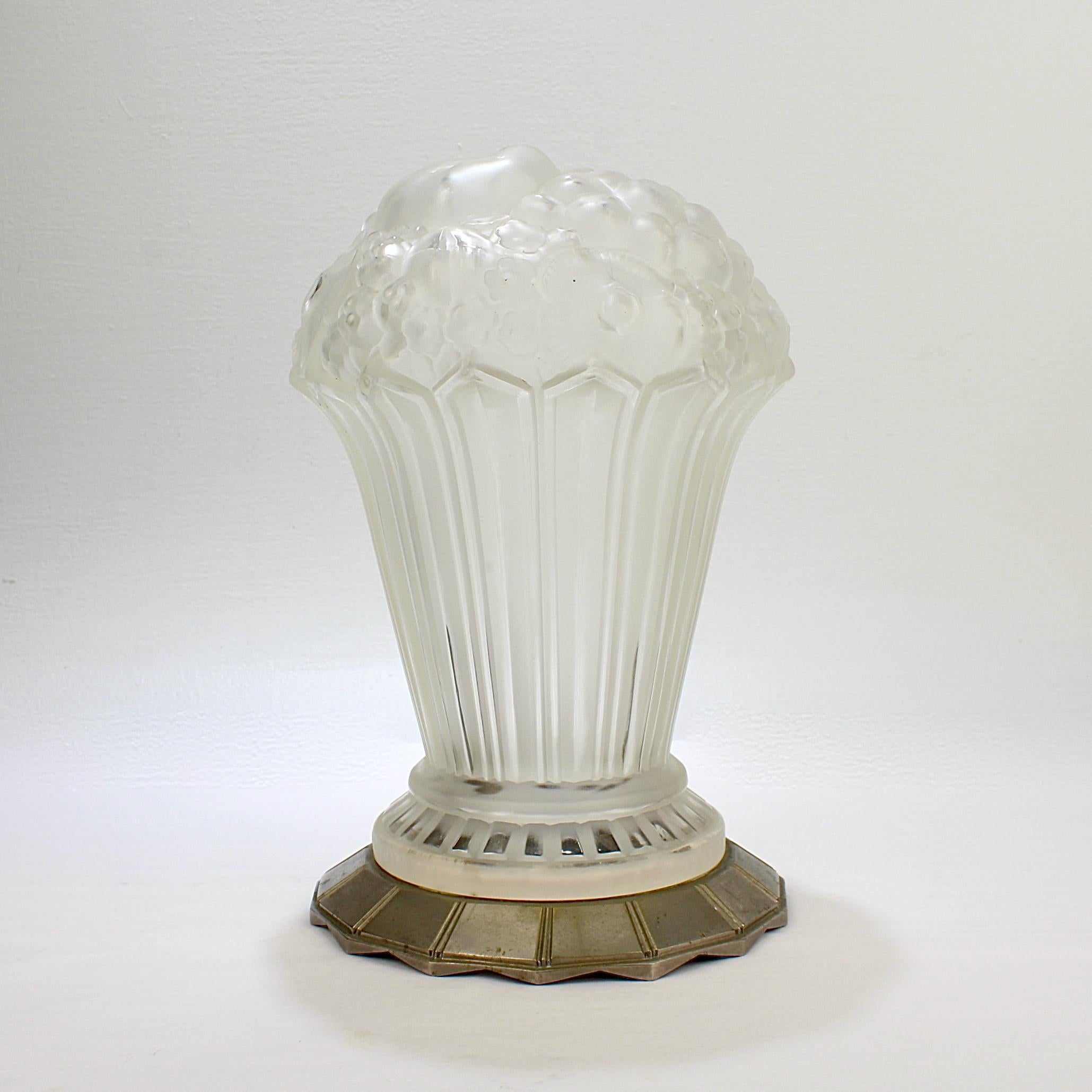 An extraordinarily fine and rare French art glass table lamp shade.

The shade is constructed of molded and frosted glass in the form of a floral and fruit bouquet and supported by a nickel-plated bronze base.

It was made by the French Art Deco