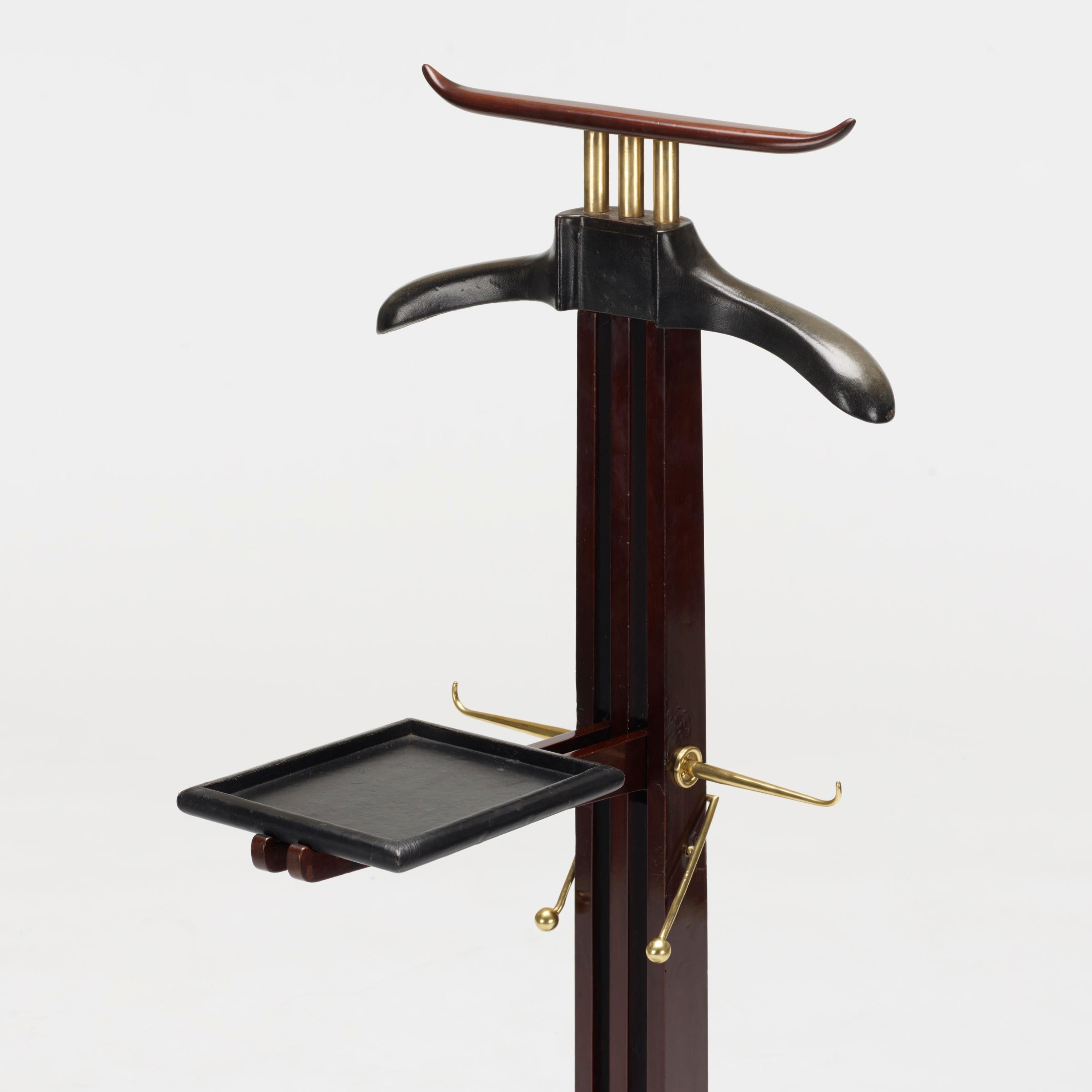 Rare gentleman valet by Paul Dupré-Lafon for Hermès. The coat hanger and foldable shelf covered in black stitched leather, also fitted with two polished brass tie hooks and the base fitted with a polished brass shoe rack.
Paul Dupré-Lafon was known