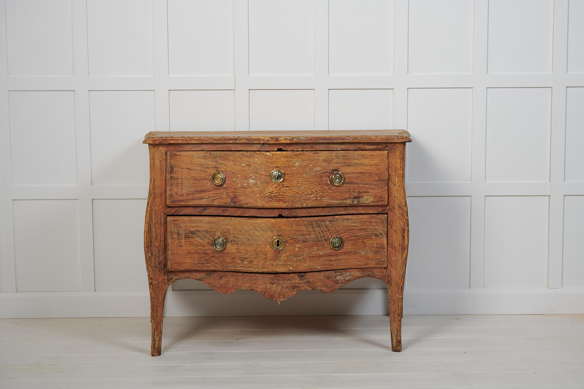 Rare genuine antique Swedish rococo chest of drawers from northern Sweden. The chest is made by hand in Swedish solid pine around 1770. It has curved drawers and table top. The chest has traces of the original paint which has authentic distress and