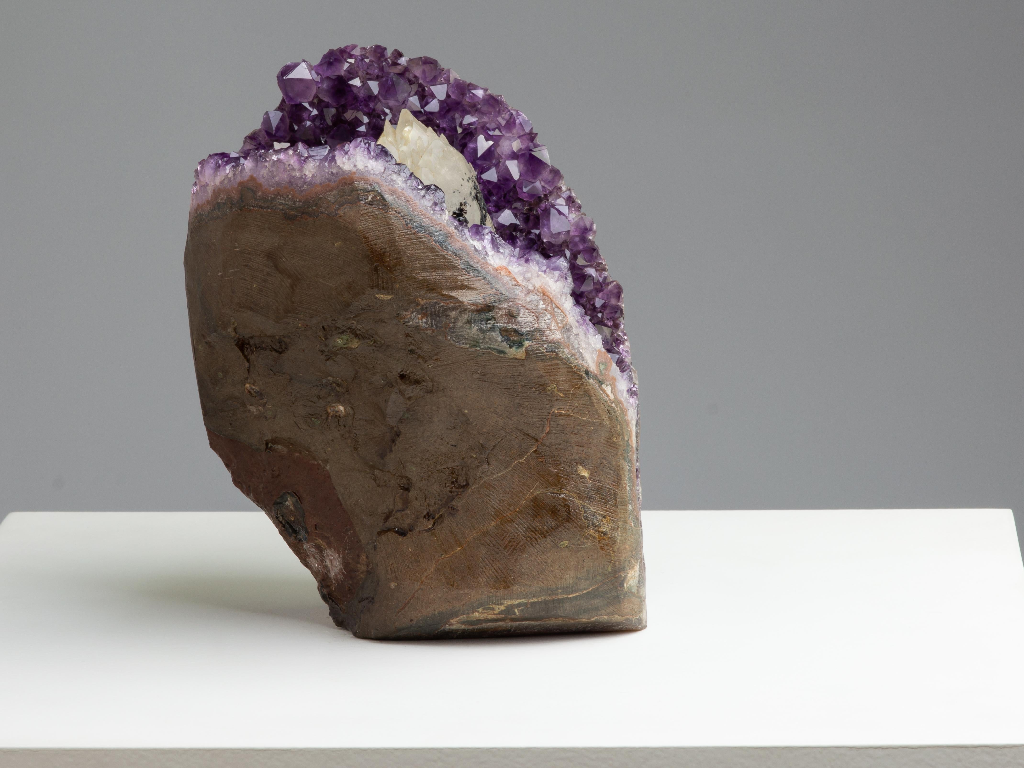 An exceotional geode cluster with deep purple Amethyst crystals with a central calcite covered with a blanket of Goethite.

A stunning, rare piece with an incredible shape resembling an 