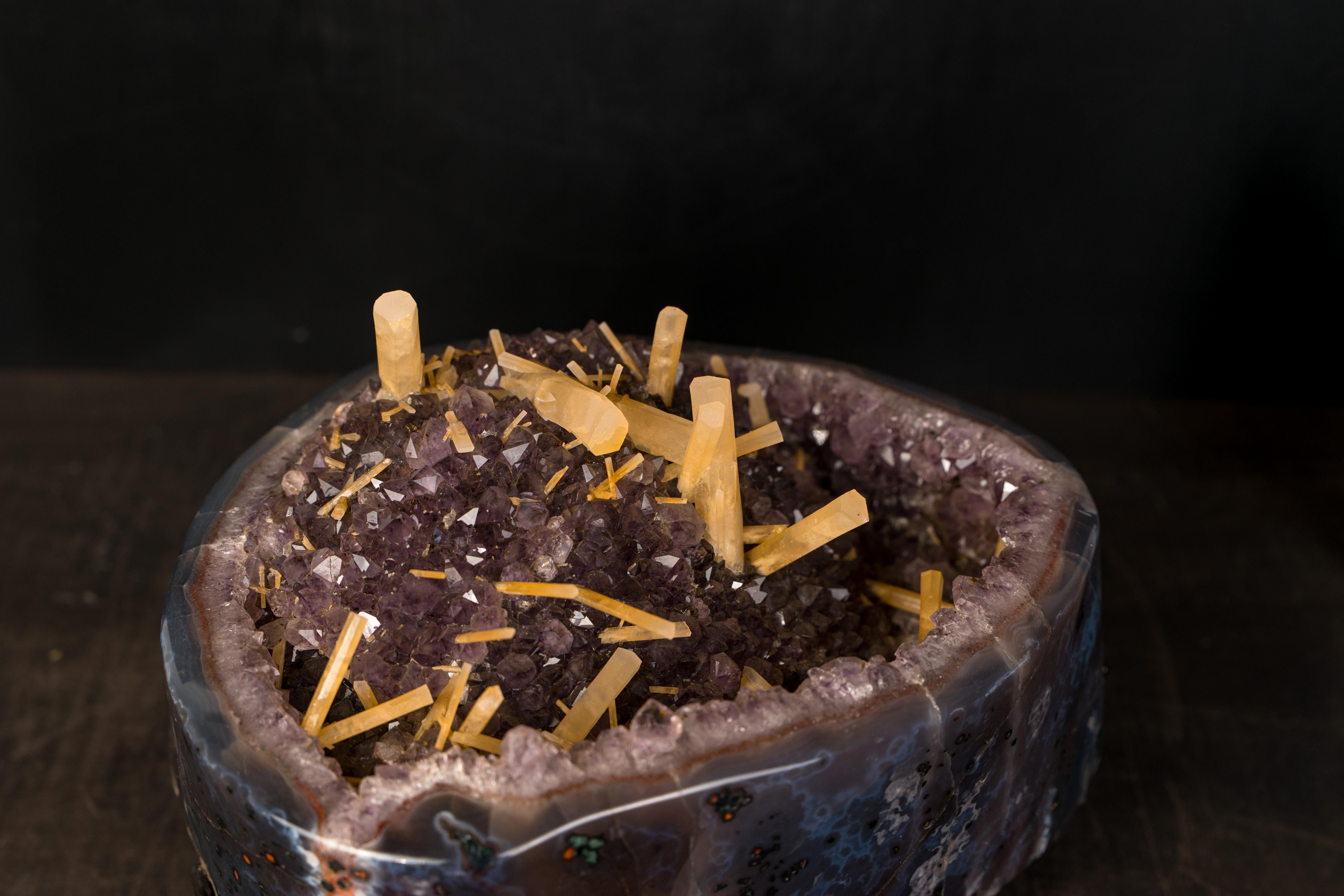 Amethyst Geode with Rare Yellow Needle Calcite

�▫️ Description

A stunning Amethyst geode filled with rare Yellow Needle Calcite, this piece brings strong aesthetics, contrast, and personality. The purple amethyst druzy creates a base where dozens