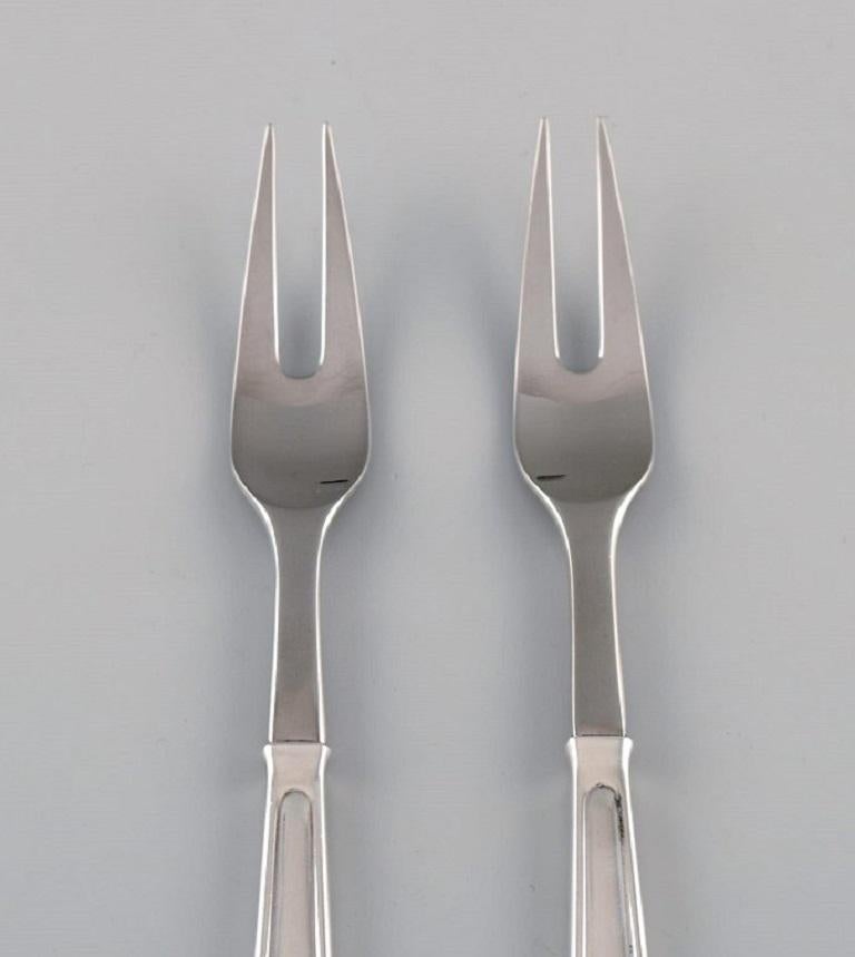 Rare Georg Jensen Koppel cutlery. Two roast forks in sterling silver and stainless steel.
Length: 20 cm.
In excellent condition.
Stamped.
Designed by Henning Koppel in 1981.
Our skilled Georg Jensen silversmith / goldsmith can polish all silver