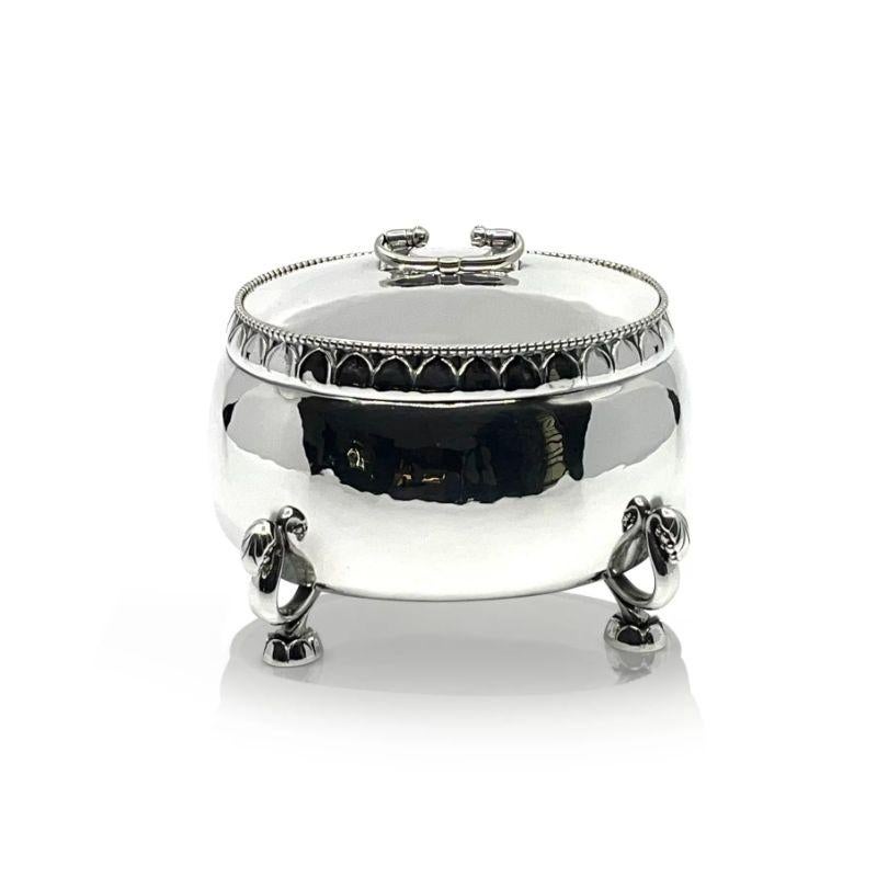 A large and very early Georg Jensen sterling silver bonbonniere, design #298 by Georg Jensen from circa 1919. A large oval hand hammered bonbonniere, the lid lifts off, the handle is hinged. The rim is beaded and chased, the feet are decorated with