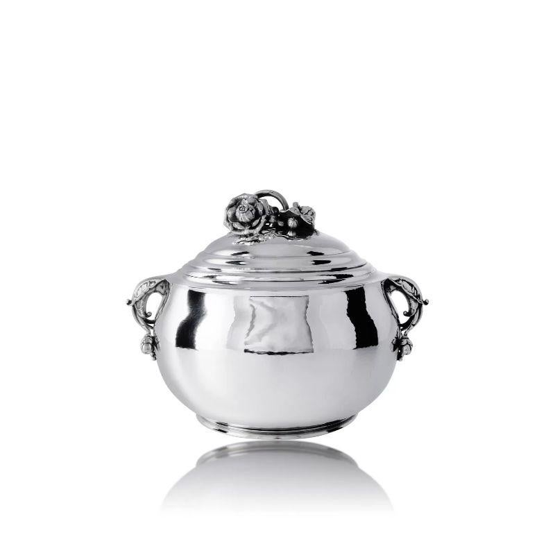 The vintage sterling silver Georg Jensen tureen is a rare and exquisite example of Art Nouveau design. Created around 1920 by the renowned Danish silversmith Georg Jensen, this tureen features stunning floral decorations that exemplify the beauty of