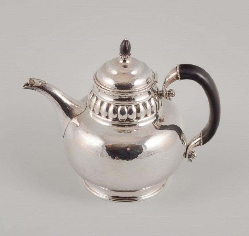 Rare Georg Jensen teapot in three-towered silver, 830.
Handle and lid knob of carved ebony. With a hinged lid.
Marked with 1915–1930 mark. Design number 49.
French import marks.
In excellent condition.
Measurements: H 20.0 cm.