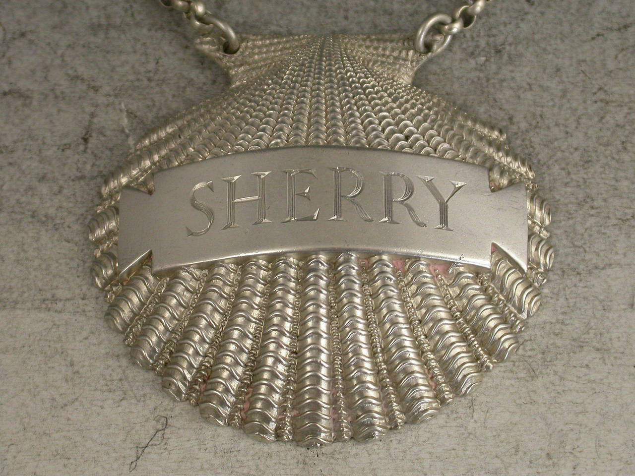A fine quality and rare George III heavy cast silver wine label made in the form of a scallop shell, the applied name plate incised for Sherry. 

By Benjamin Smith, London, 1807

In fine condition with no damage or repair

Measures: Height 51
