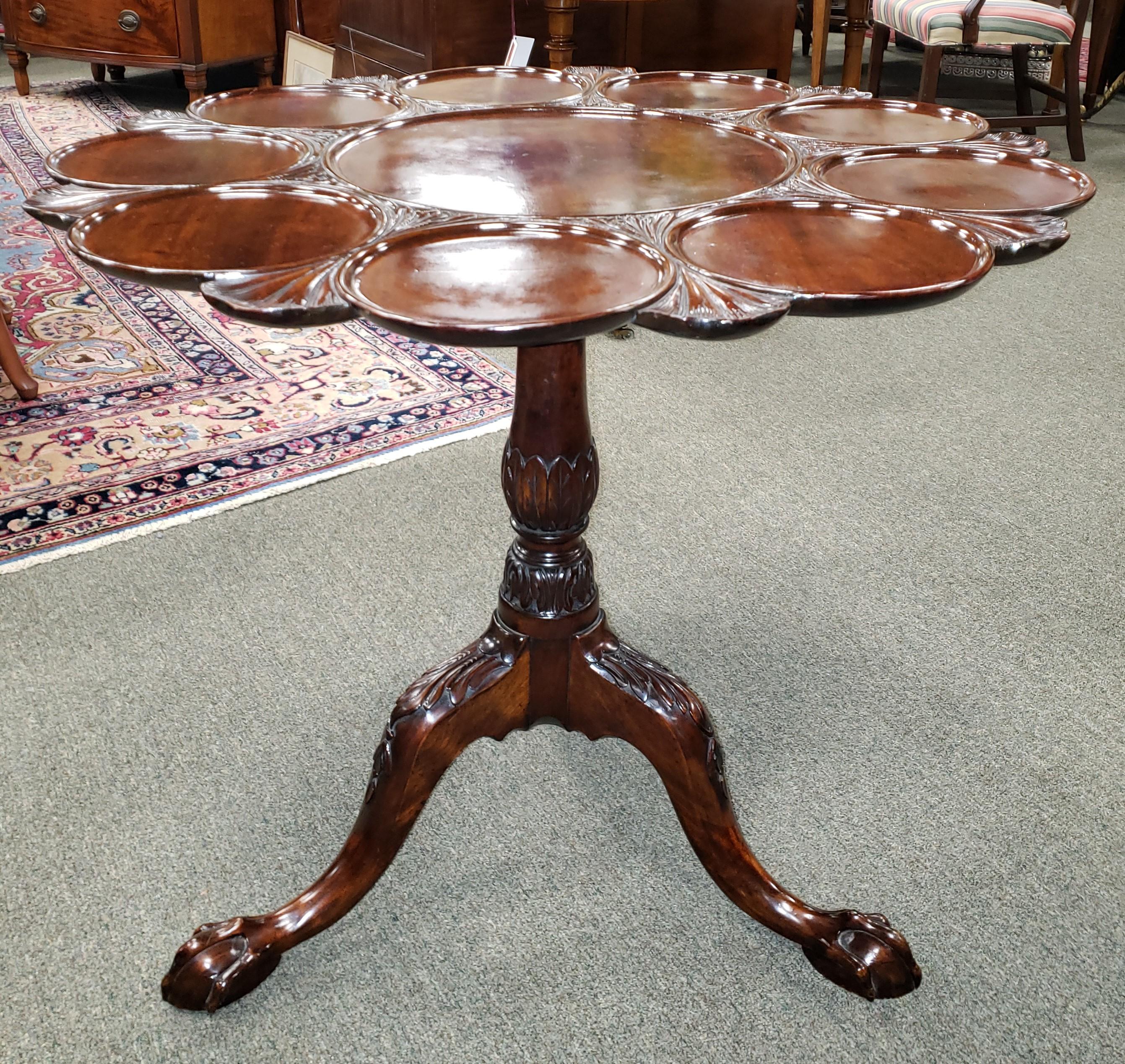 Rare and important George III English carved mahogany Chippendale style tilt top supper table. This rare and unusual table displays a top with scalloped resting spots for small serving plates and a center spot for a large platter. The elegant top is