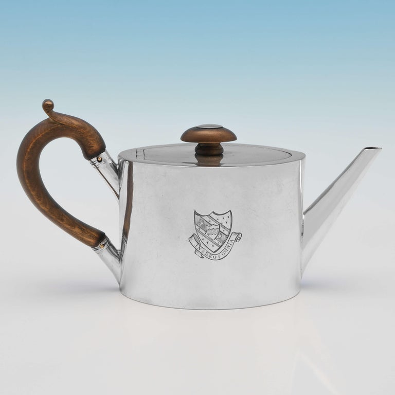 Hallmarked in London in 1802 by John Mewburn, this very handsome, rare to find, George III, Antique Sterling Silver Saffron Pot, is oval in shape, and plain in style, featuring a wooden handle and finial, and heraldic engraving to both sides. The