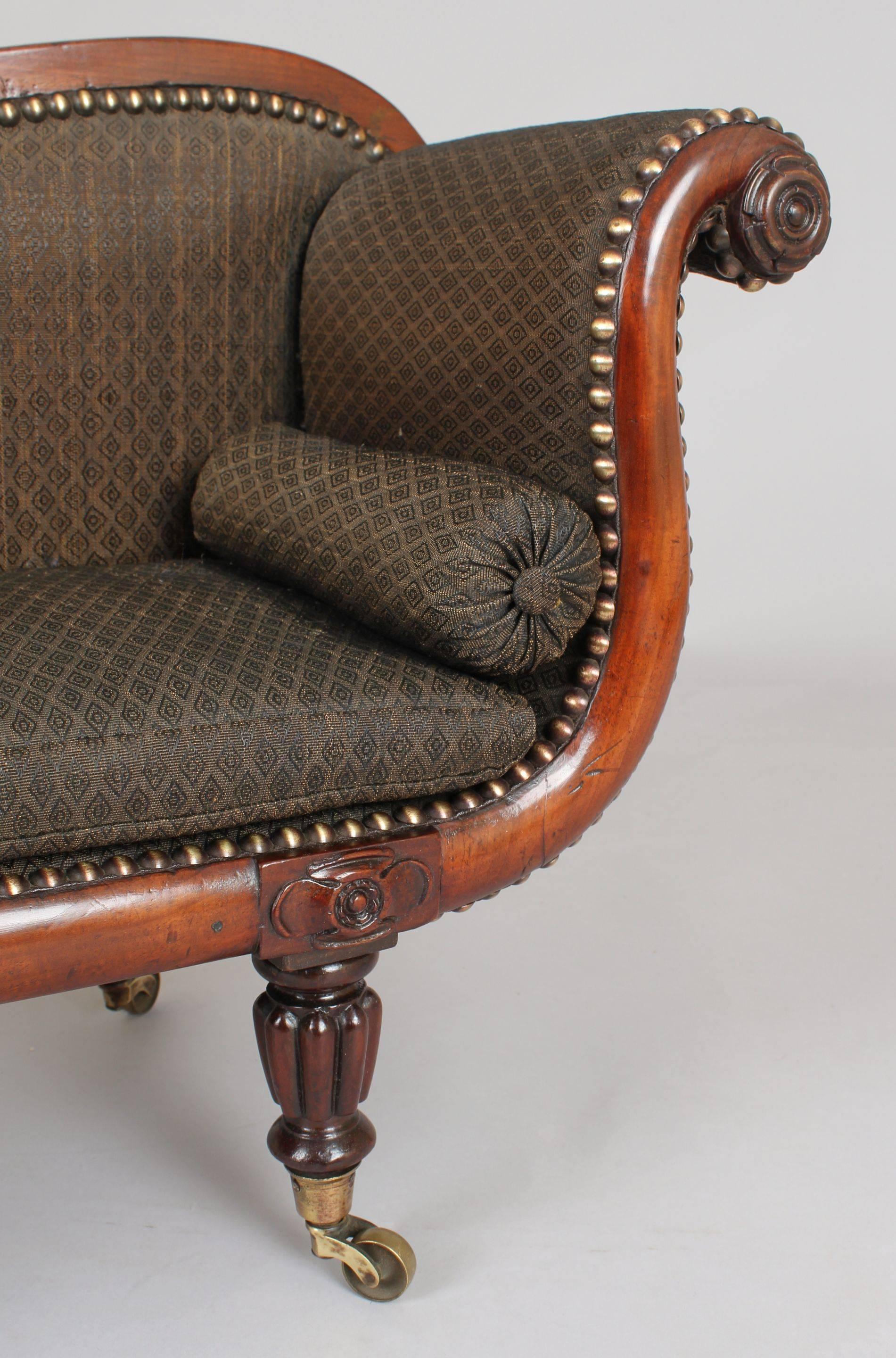 Rare George IV period mahogany miniature sofa; the finely proportioned scroll-ended frame with carved rosette decoration, on four turned and reeded legs with brass cap-castors; the frame, seat squab and bolsters with their original black woven