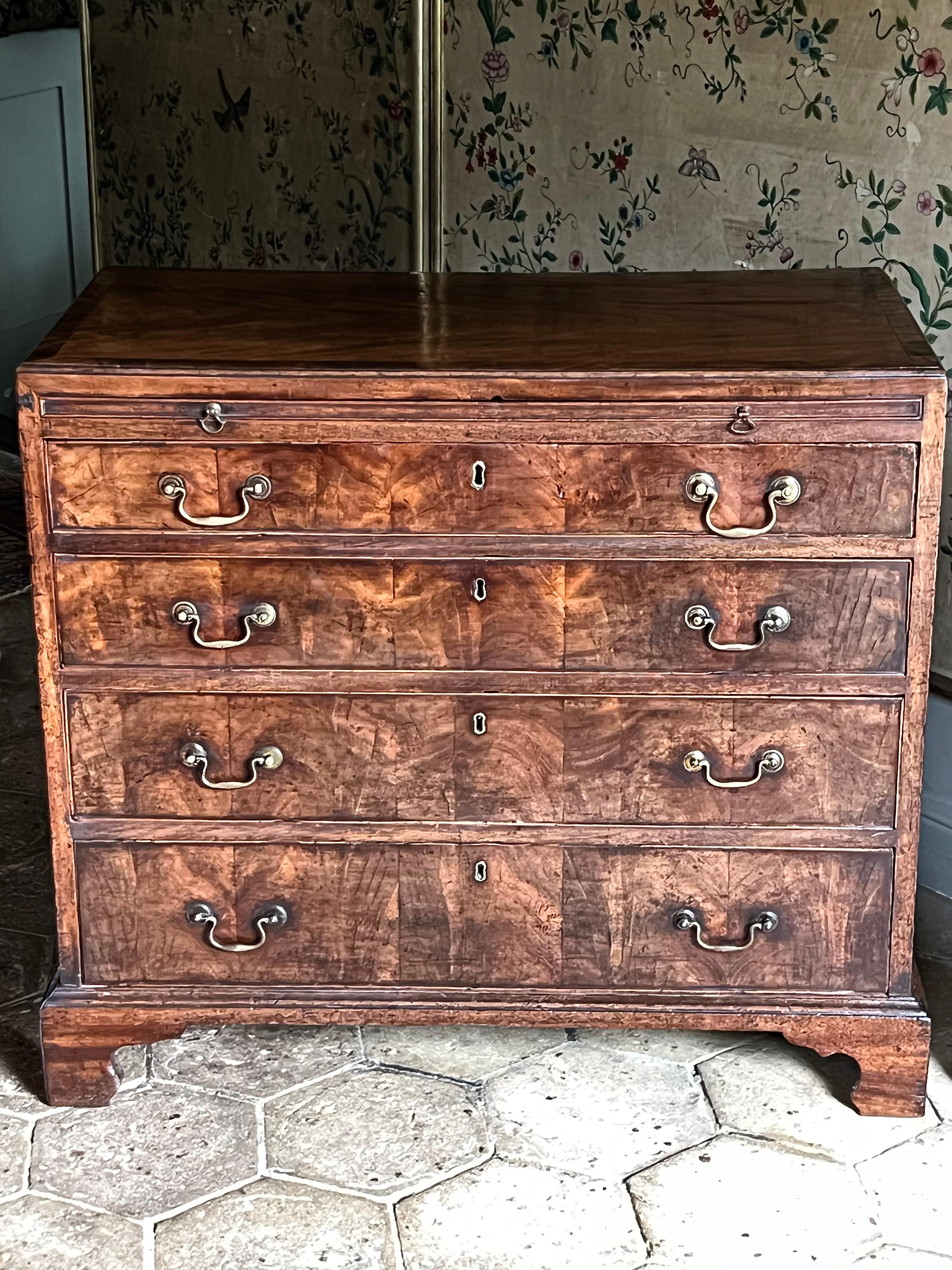 An English George III-period walnut and mahogany caddy-top bachelor’s chest. Mid-eighteenth century, ca 1760.

This is a superb quality bachelor chest with slide, in a rare combination of well-figured walnut and mahogany of deep, rich