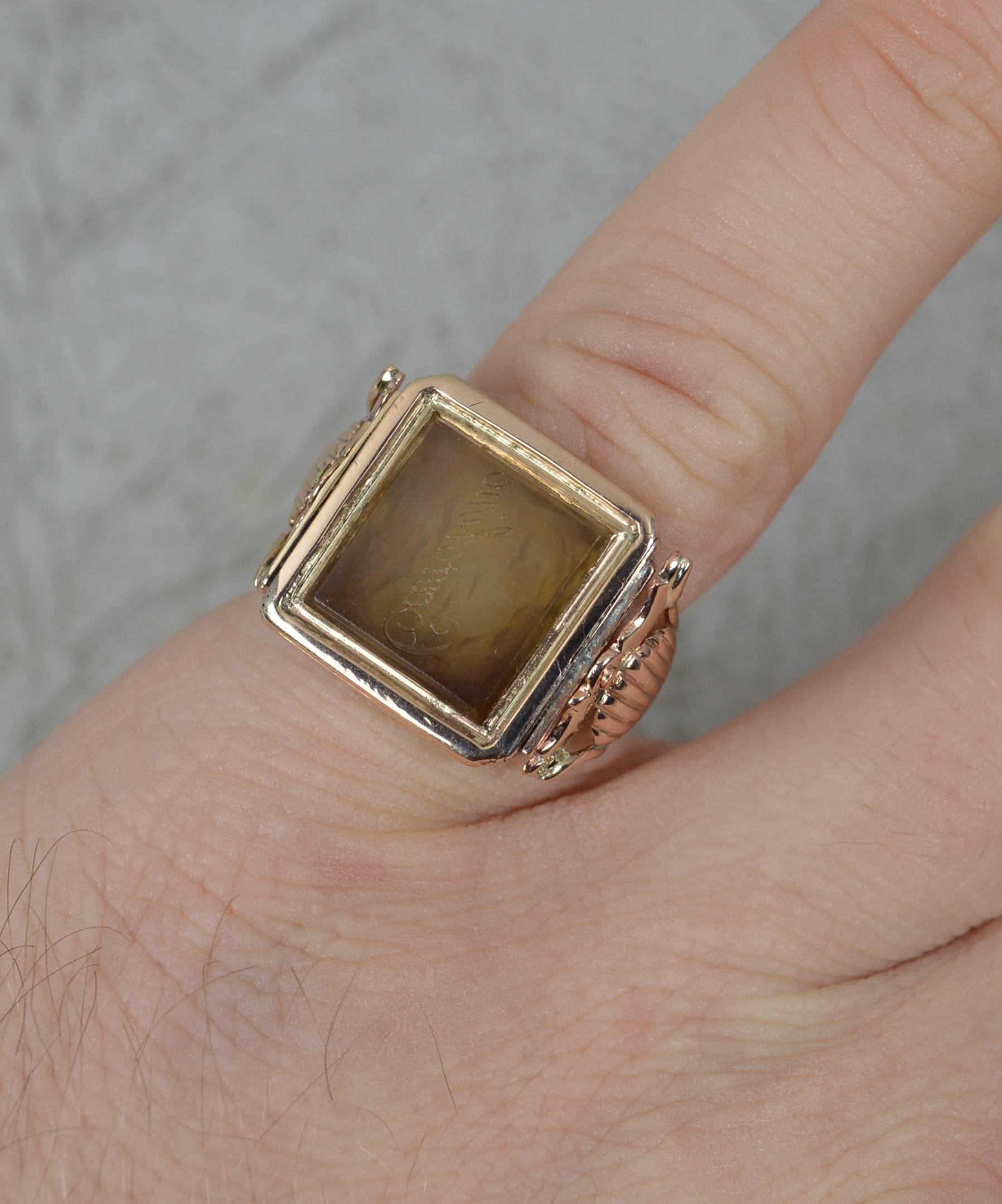 A Georgian era ring circa 1820.
Solid 15 carat rose gold example with pierced shell shank.
Designed with a square agate panel whch swivels. 15mm x 15mm head.
The stone is plain to one side and engraved Caroline the other.

CONDITION ; Very good for