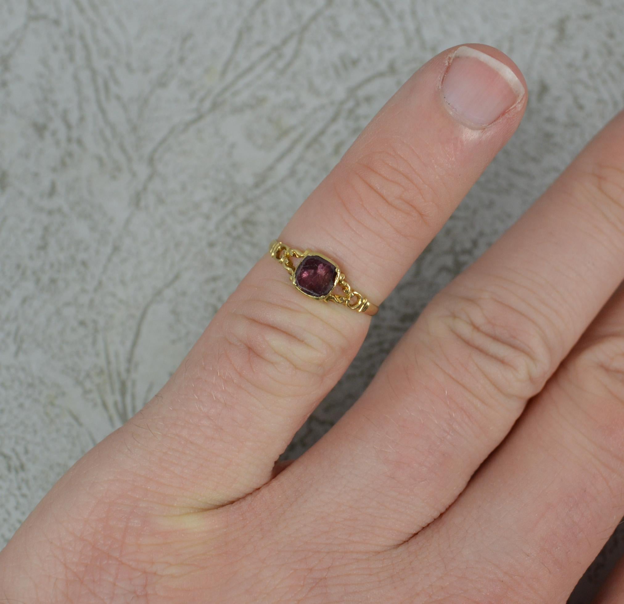 A superb Georgian period ring. Circa 1790.
Solid 18 carat yellow gold example.
Designed with one single flat cushion shaped garnet. 4.5mm x 4.5mm approx. With a pierced head to the sides.
Closed, foiled back, bezel setting.
A very small finger size,
