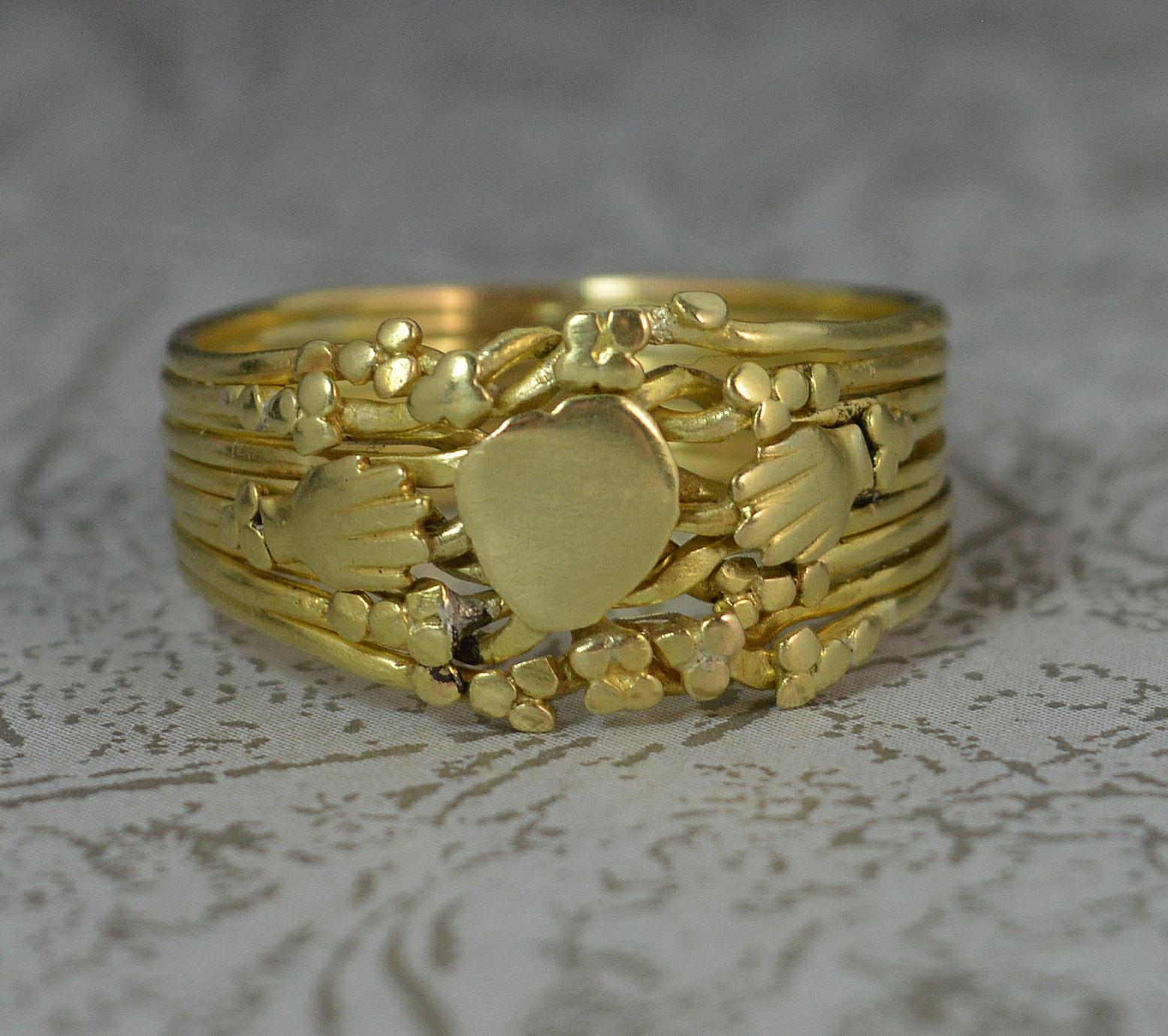 A superb true mid Georgian era Fede band ring, c1760.
18 carat yellow gold example.
Designed as nine bands creating a puzzle ring design. The cluster depicts a heart to centre with hands to each side and flower gold balls surrounding.
A fede ring is