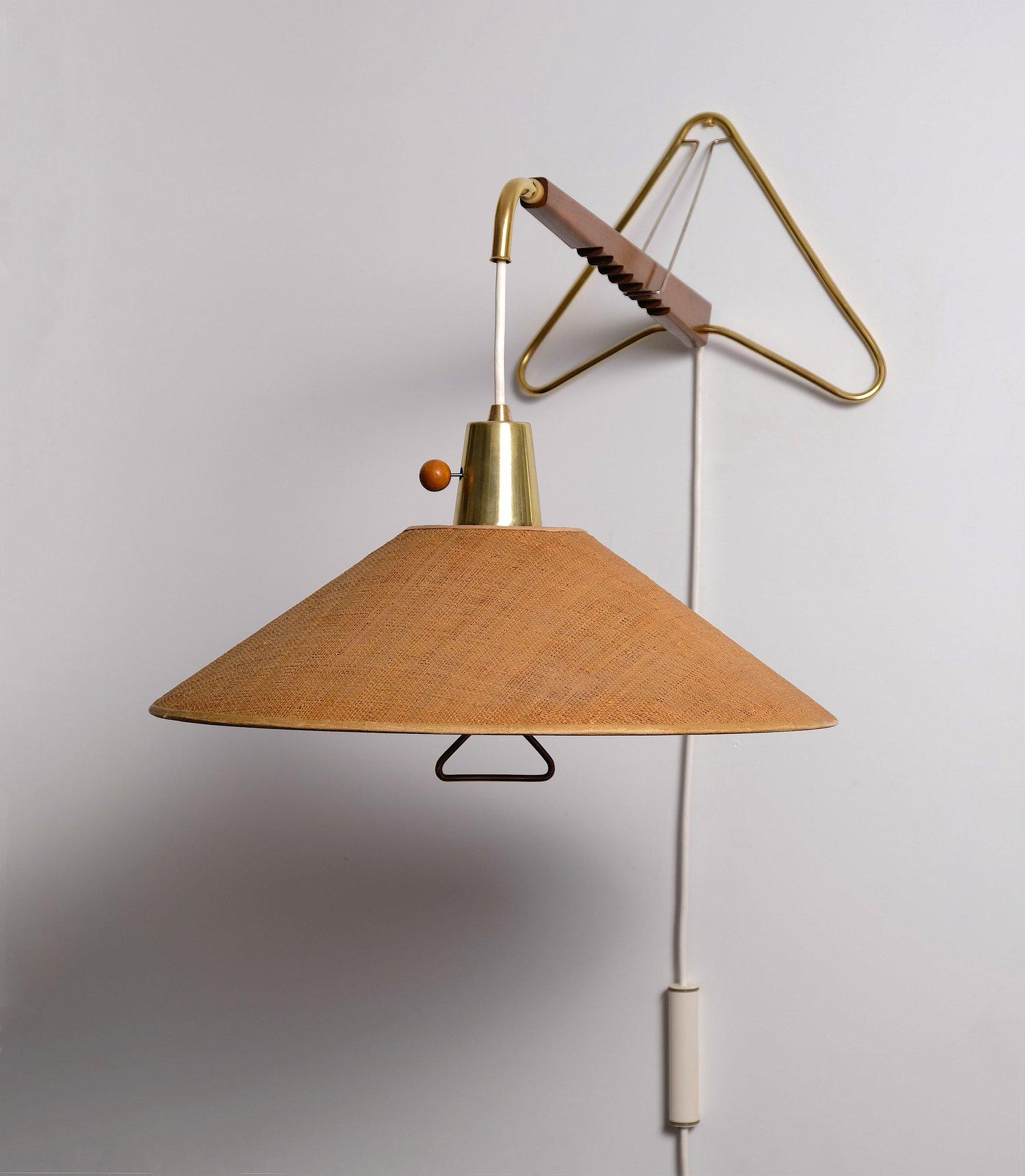 Rare Gerard Thurston extensible and adjustable wall lamp in walnut and brass with original raffia grass shade. The lamp can be extended by pulling out the brass arm and the angle can be adjusted with the notched wall bracket.  Includes a pierced