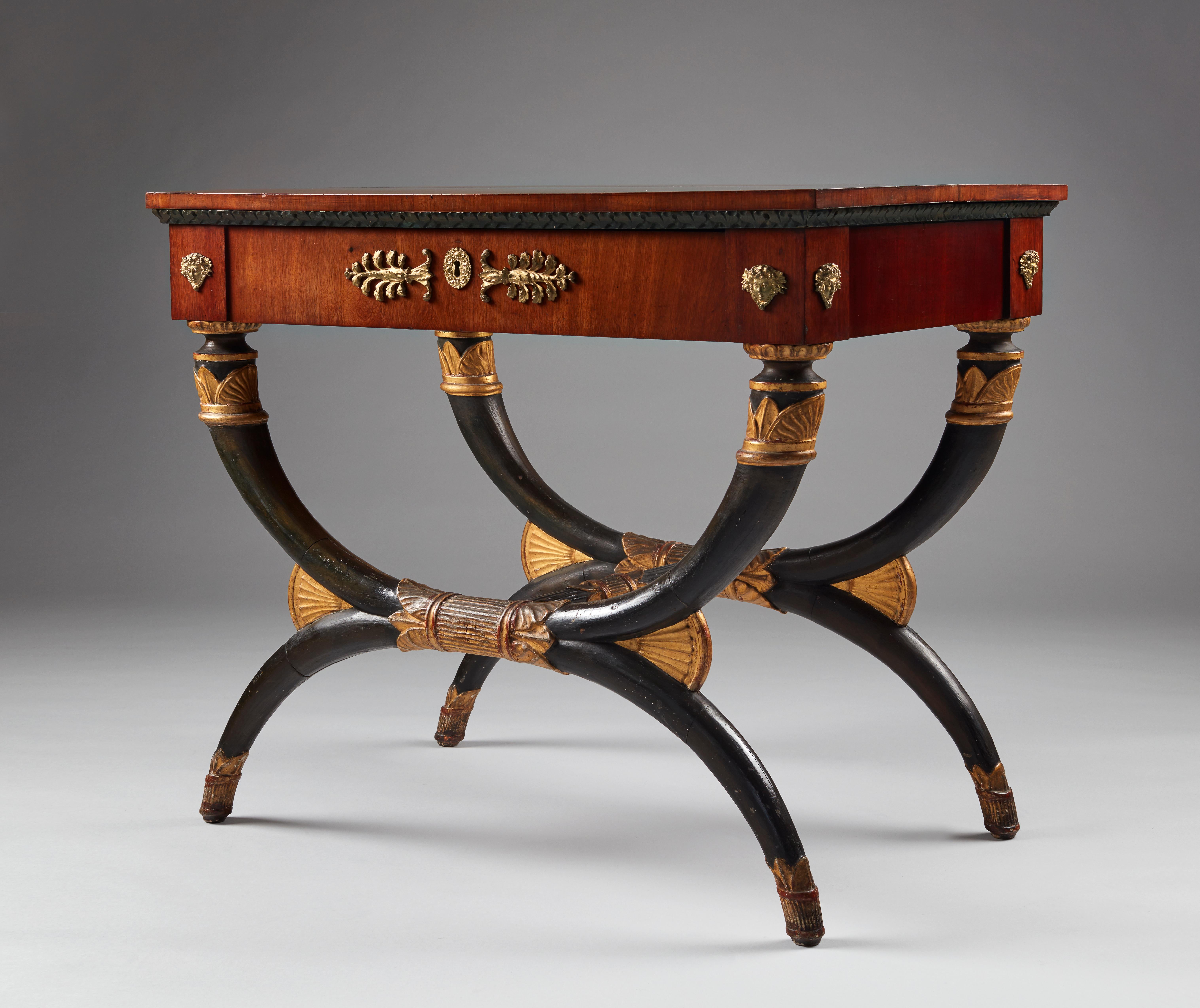 An early 19th century German (Saxony) Empire painted and parcel gilt mahogany console table, which can also be used as a center table. With one central frieze drawer above an X-frame base, that alludes to an ancient form, the Curule seat, which