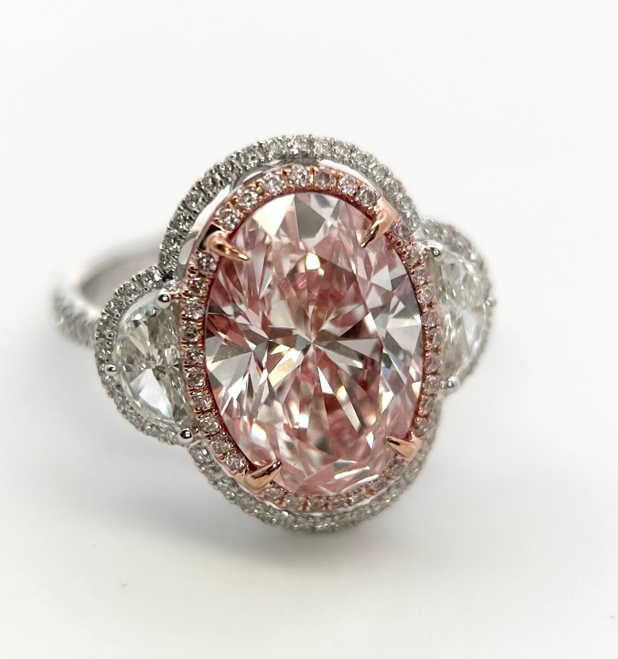 Extrêmement rare et très recherchée, la bague à trois pierres en or blanc et rose 18 carats, certifiée par le GIA de type 2a ou IIa, avec une grande taille ovale de 6,00 carats de diamant rose naturel et de diamant blanc. Il s'agit d'un diamant rose