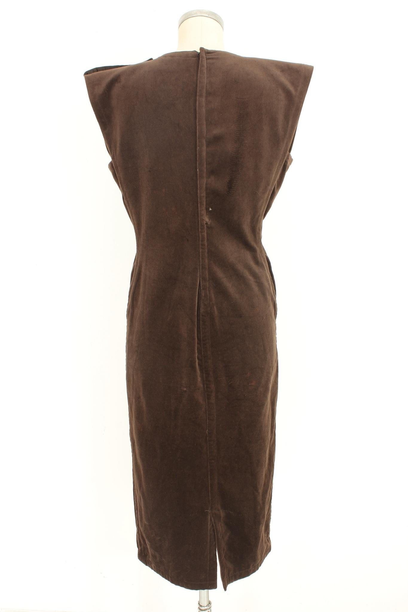 Gianni Versace long 70s vintage evening dress. Silk velvet dress, sheath model, sleeveless, ankle length, two buttons with Swarosky on the shoulder and waist. Zipper closure along the back. Brown colour, 100% silk fabric. Made in Italy.

Size: 42 It