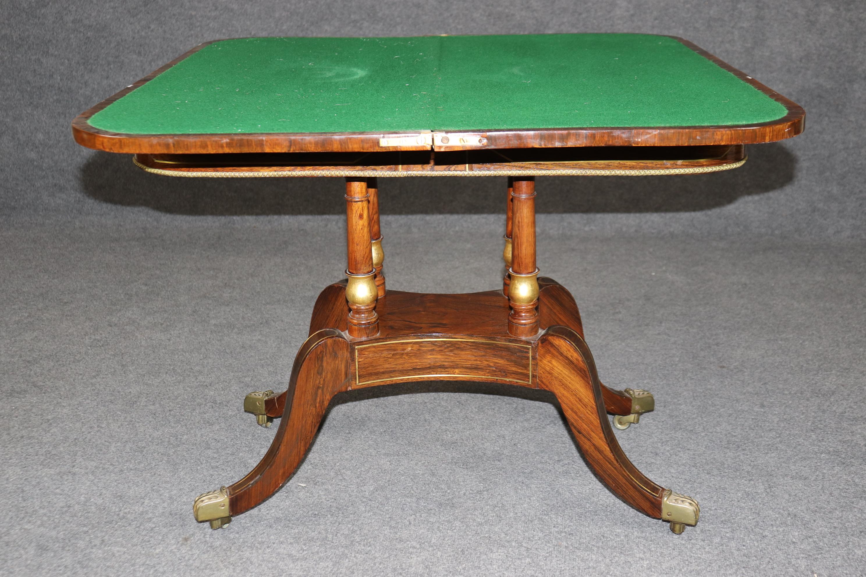 Si tratta di un superbo tavolo da gioco inglese del 1820 con legno di palissandro pregiato e splendidi intarsi in ottone. Il tavolo ha un bel feltro verde per le carte da gioco e una bella finitura antica. La base presenta piedi a zampa in ottone e