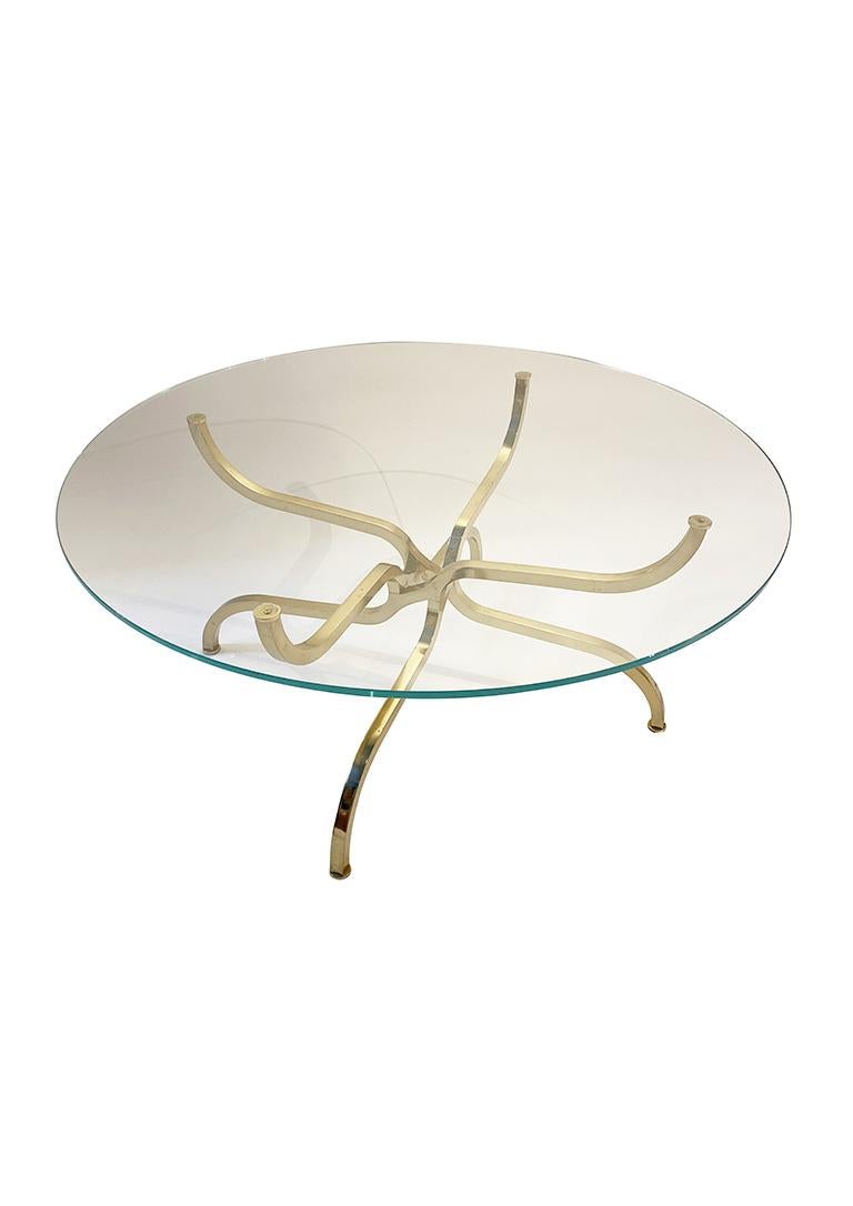 Very rare coffee table designed and edited by Georges Geffroy in the 1960s. 

Round glass top resting on a magnificent gilded metal base with four intertwined legs. 