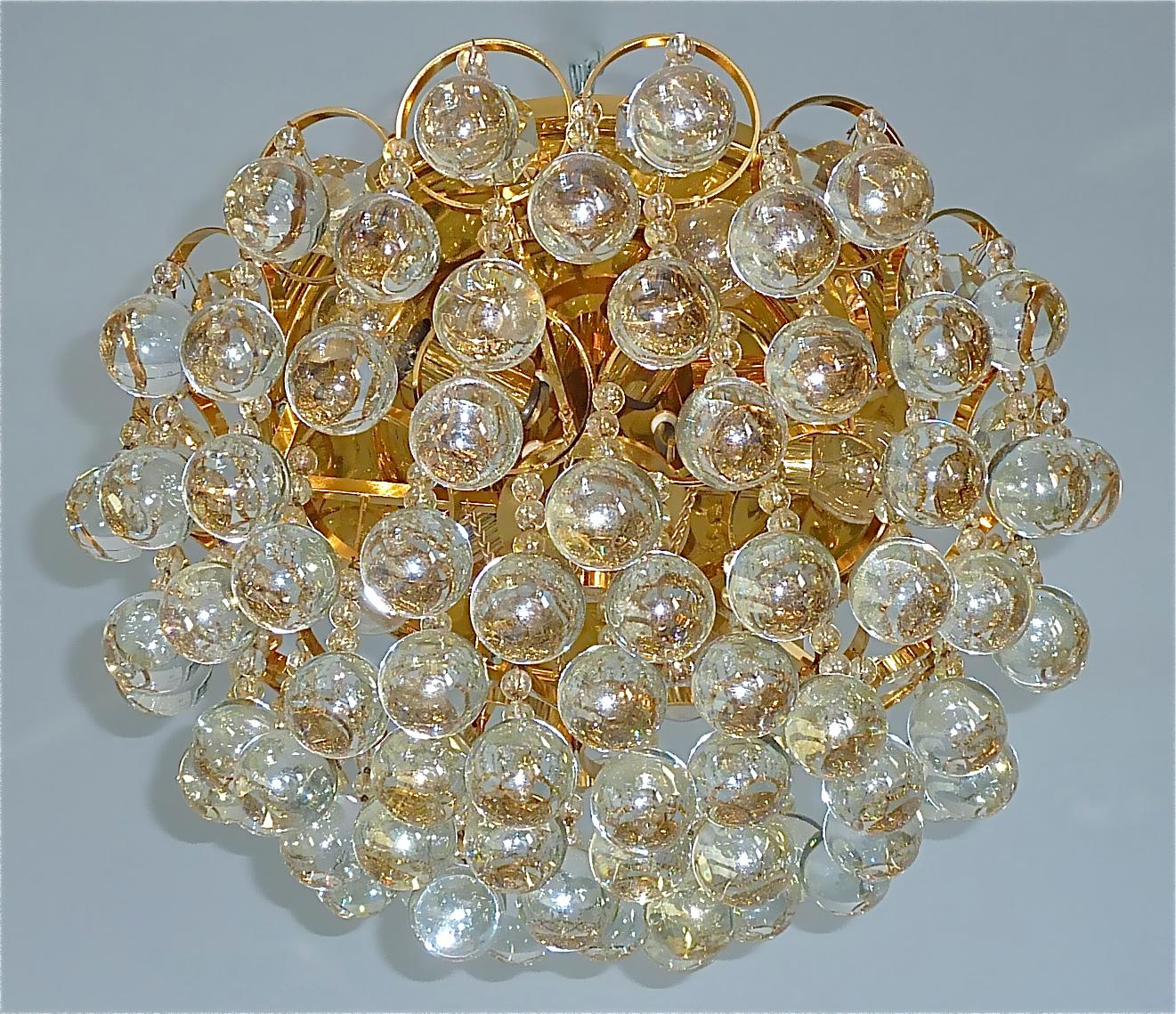Rare and magnificent gilt brass metal flush mount chandelier by german first class lighting company Palwa, Germany circa 1960-1970. The chandelier has lots of hand-crafted glass pearls and spheres of very faint amber shimmering shiny iridescent