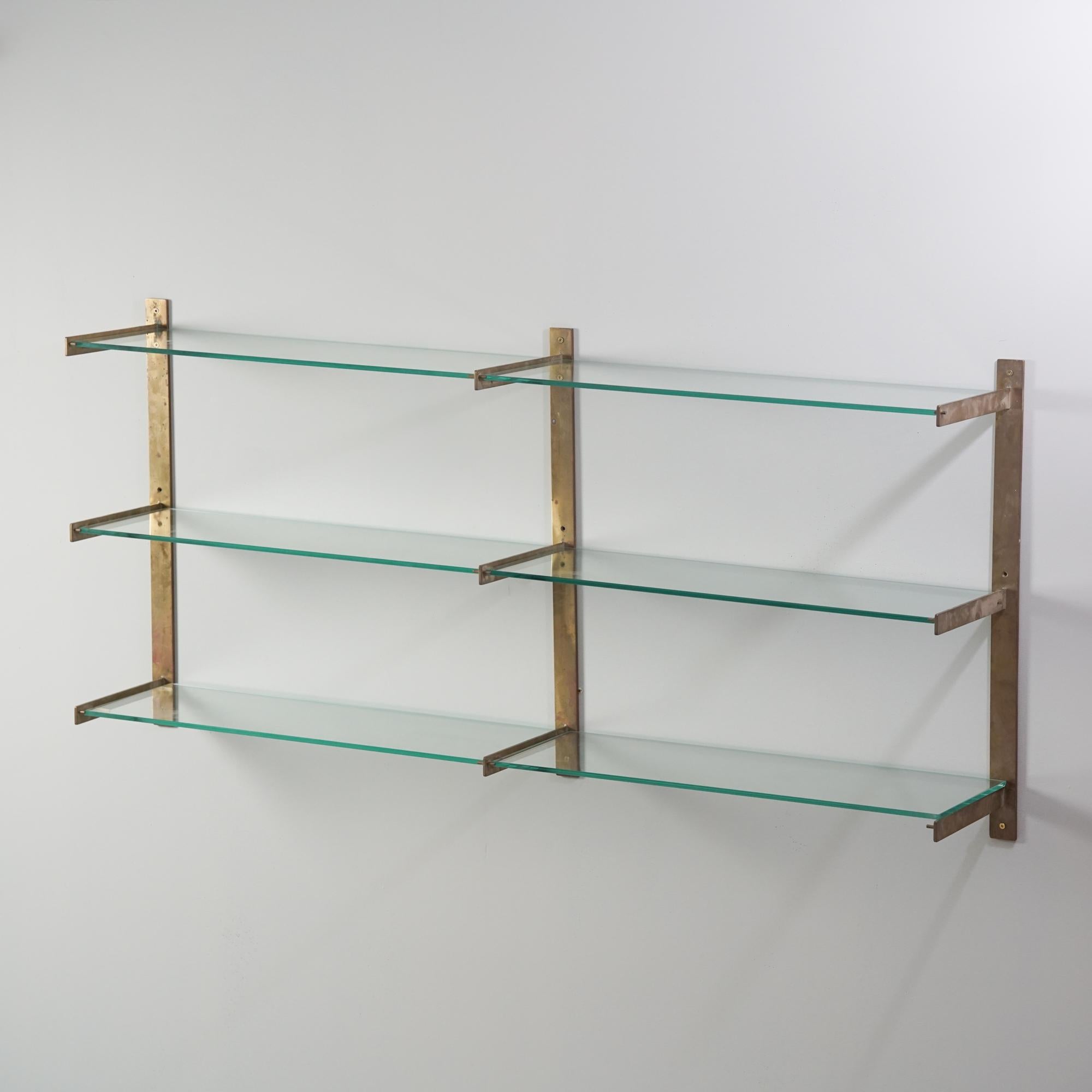 Rare glass and brass wall shelf system, designed by Ahti Taskinen, 1960/1970s. Brass frame, glass shelves. Good vintage condition, patina consistent with age and use. Timeless Scandinavian Modern design. 