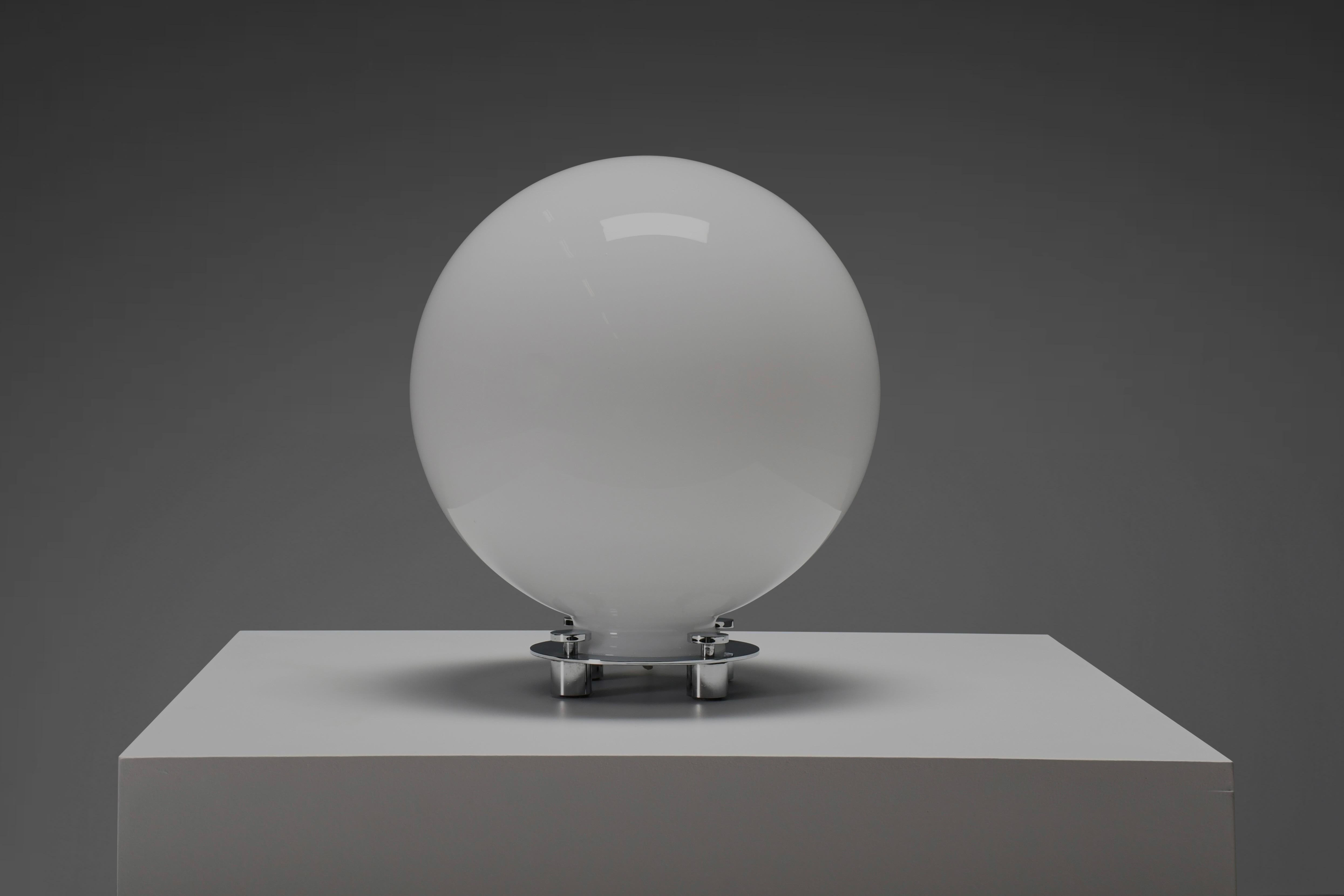 Beautiful model 752 globe table lamp in excellent condition.

Made by Martinelli Luce, Italy 1970s 

The lamp is composed of an oversized globe shade in white handblown glass which is supported by a chrome metal circular base.

The base keeps the