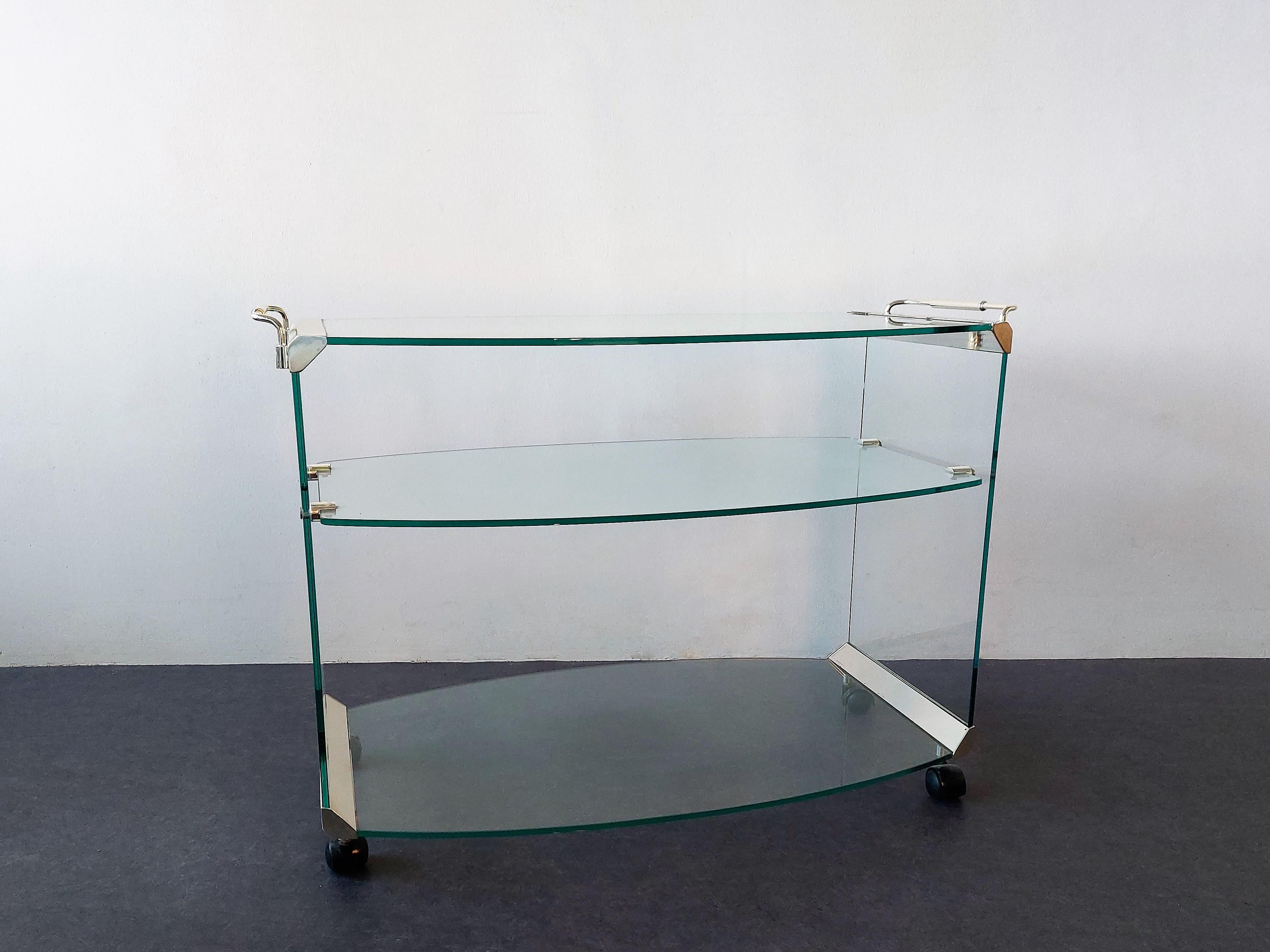 This elegant bar cart or serving trolley was made by Gallotti & Radice in Italy in the 1970's. A design of Pierangelo Galotti and part of wide range of designs. It consists out of 3 glass shelves with chromed steel connecting parts and handles. This