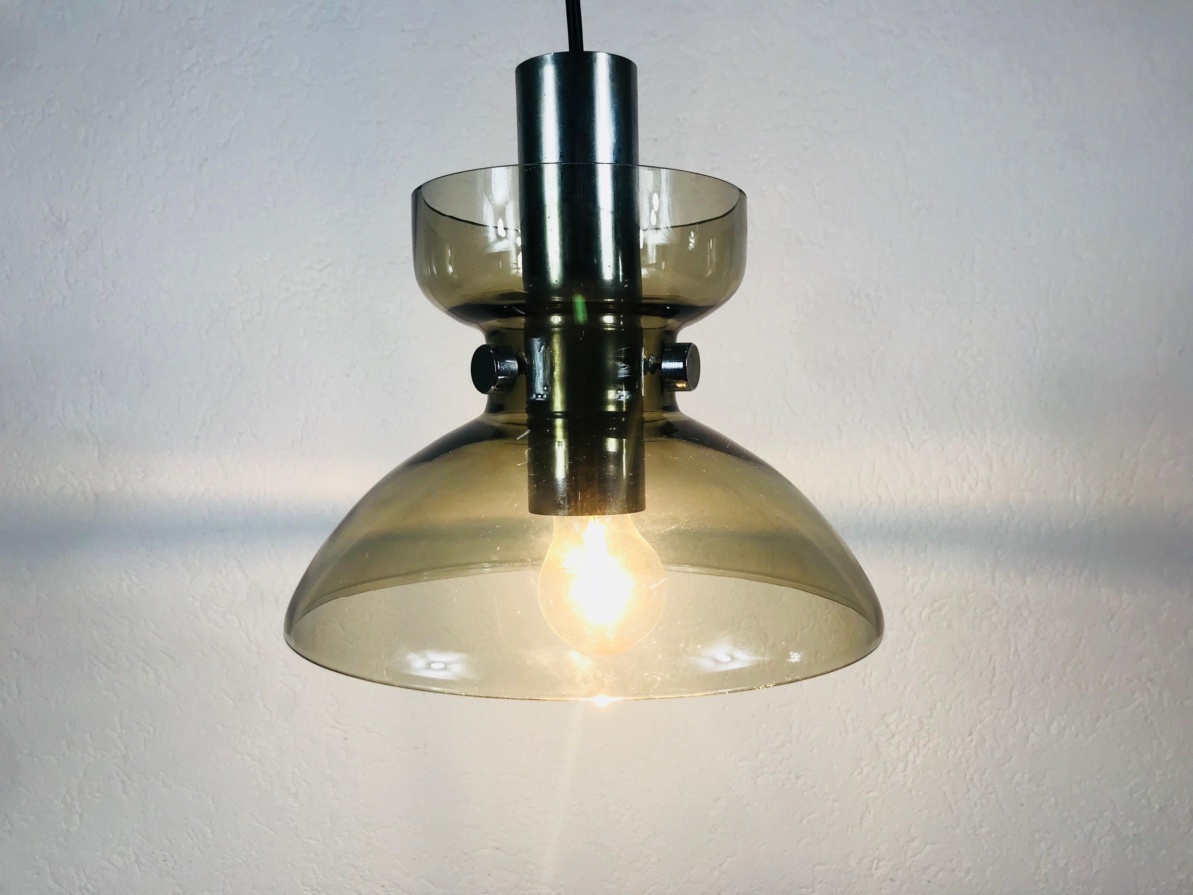 Une lampe pemdant vintage de Glashütte Limburg fabriquée dans les années 1970 en Allemagne. Il est fascinant avec sa belle forme. Il est fixé au corps métallique par trois vis à métaux.

Le luminaire nécessite une ampoule E27.