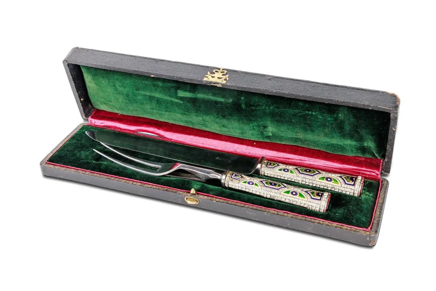 Rare service à découper en or, émail et bijoux. 

Les manches datent du 18ème siècle, Suisse et les lames du 19ème siècle, Angleterre. 

Comprenant un couteau et une fourchette, les manches décorés de panneaux de fleurs et de festons en émail bleu,