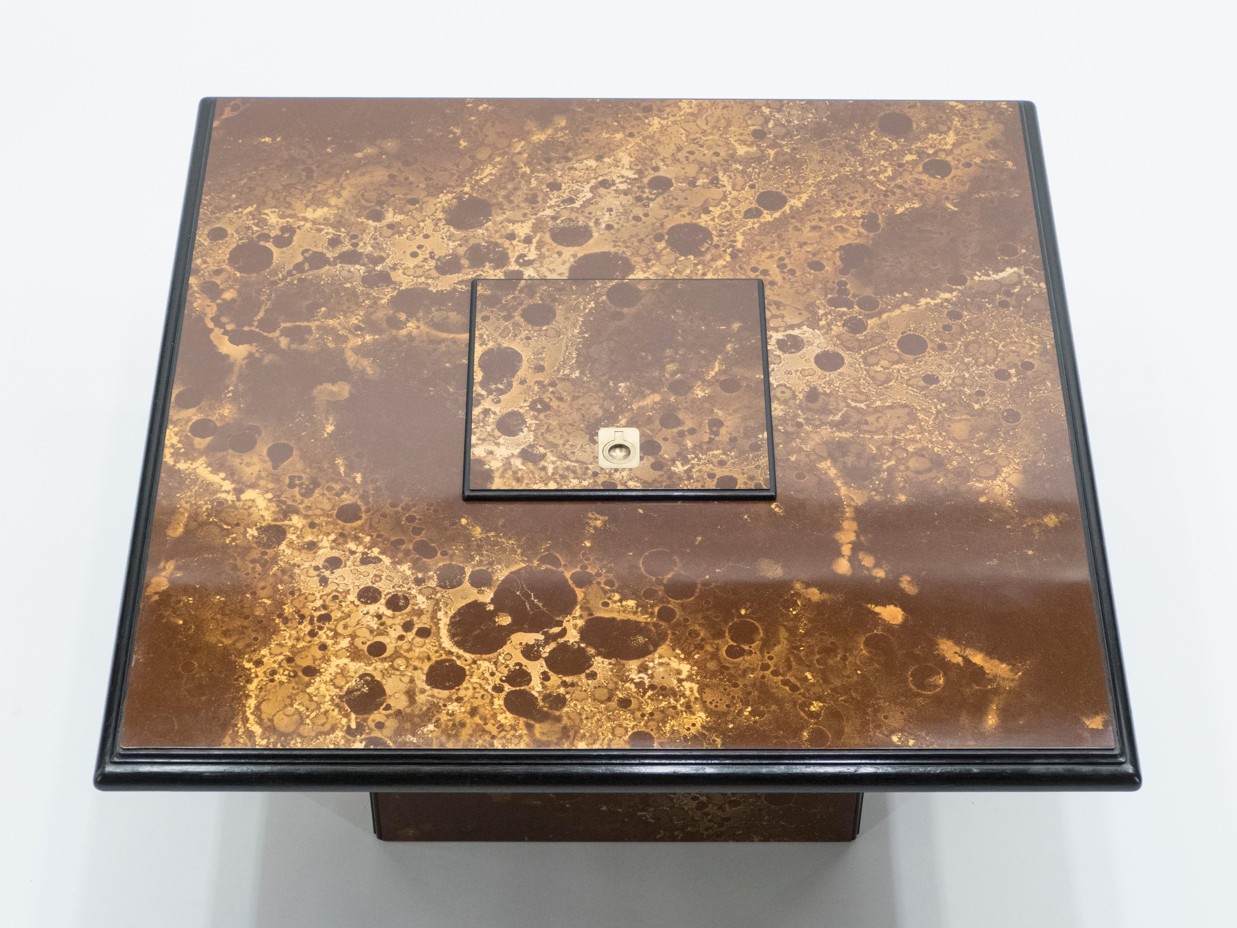 An exciting example of French design firm Maison Jansen’s commissioned pieces. This bar coffee table is made from solid mahogany, lacquered in a rich dark brown and bronze, golden finish. The resulting effect is a beautiful mottling of color around