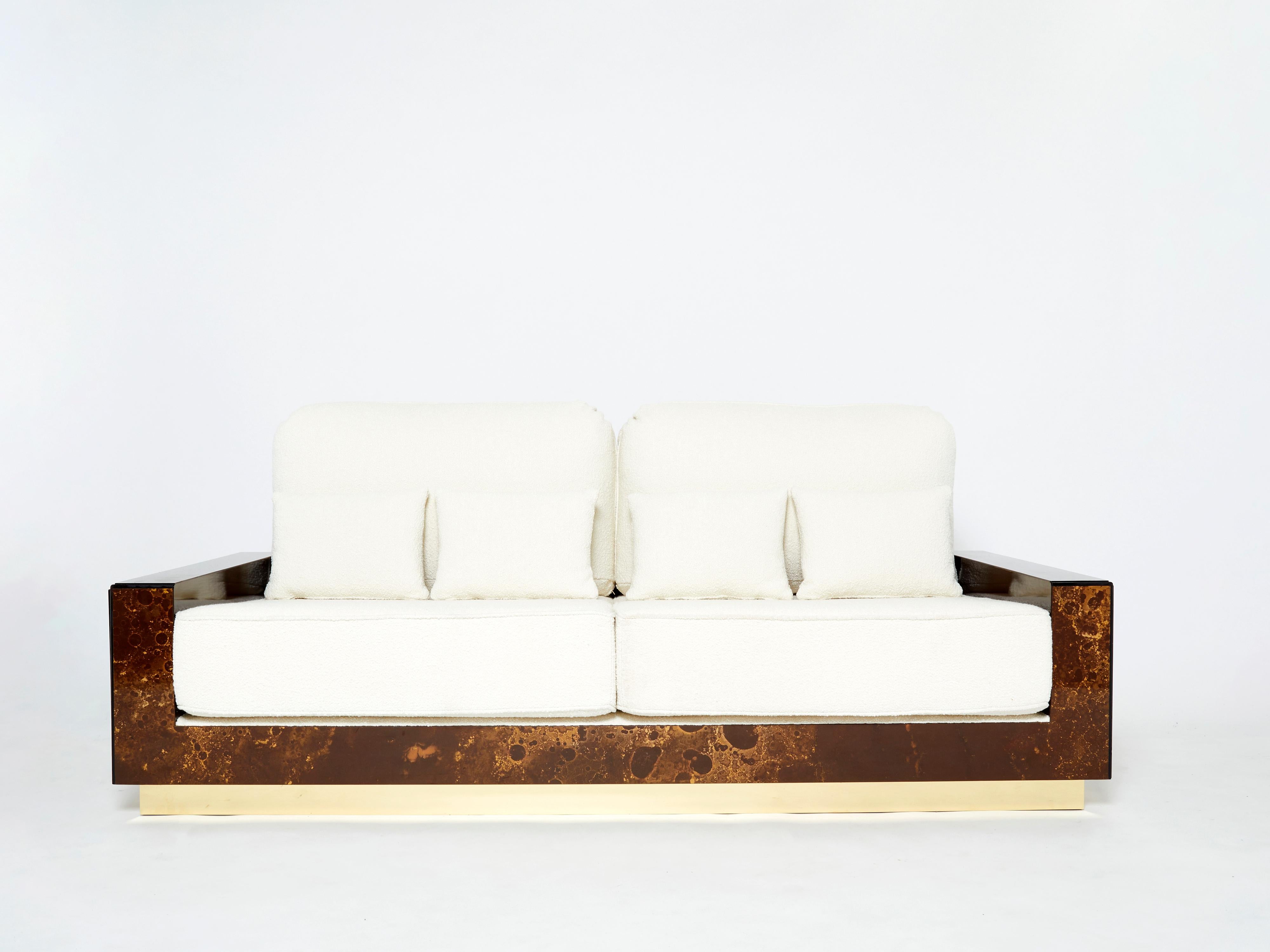 Un esempio entusiasmante dei pezzi commissionati dall'azienda di design francese Maison Jansen. Questo divano è realizzato in mogano massiccio, laccato con una ricca finitura marrone scuro e bronzo-oro. L'effetto risultante è una bellissima