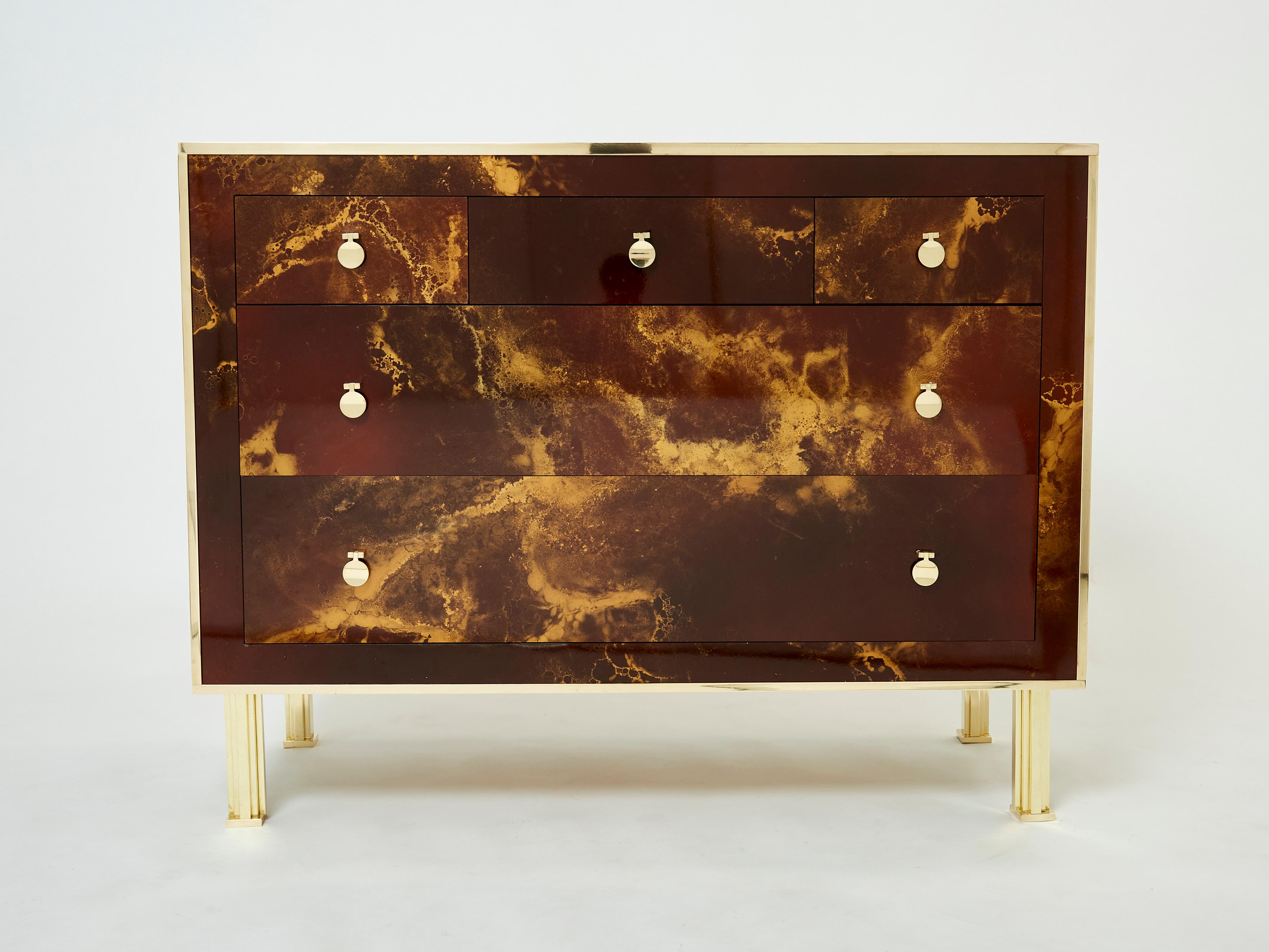 An exciting example of French design firm Maison Jansen’s commissioned pieces. This chest of drawers is made from solid mahogany, lacquered in a rich dark brown and bronze–golden finish. The resulting effect is a beautiful mottling of color around