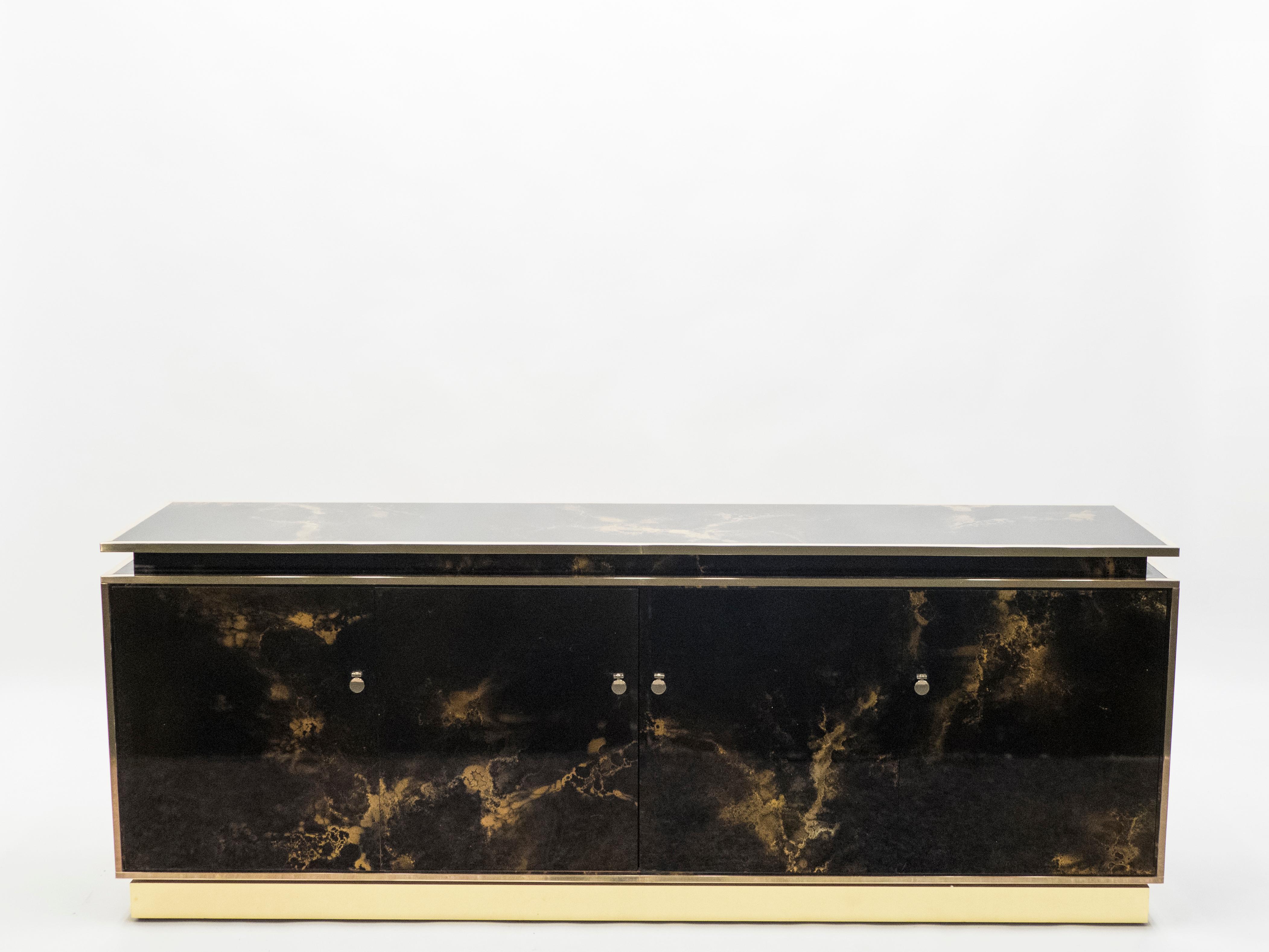 An exciting example of French design firm Maison Jansen’s commissioned pieces. This large sideboard is made from solid mahogany, lacquered in a rich dark brown and bronze–golden finish. The resulting effect is a beautiful mottling of color around