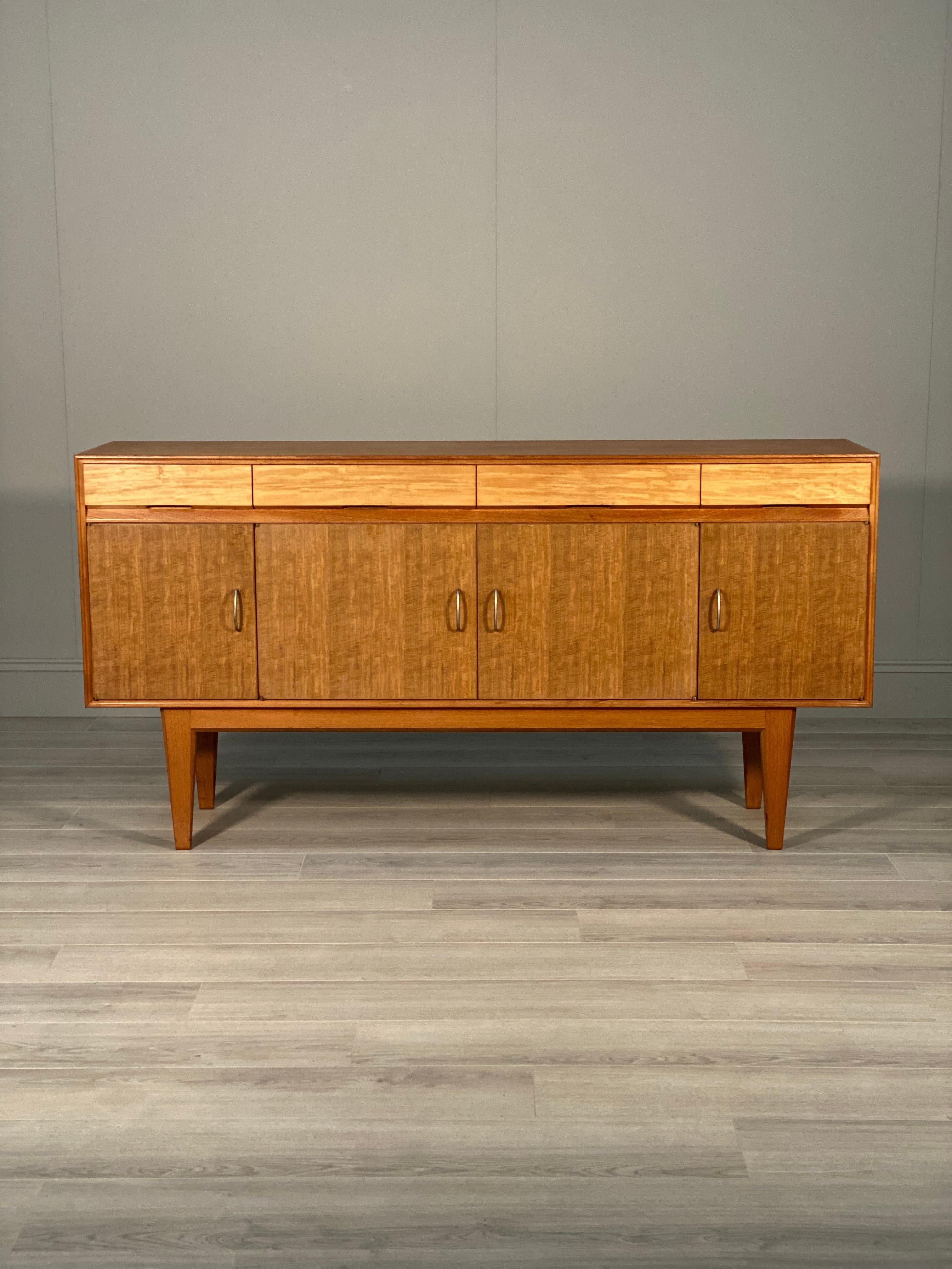 A rare Gordon Russell sideboard dating to the 1950’s. The sideboard is made from a multiple of different woods with a teak body, ebony cupboard doors and satin wood drawer fronts. In very good order with some slight age related wear.
